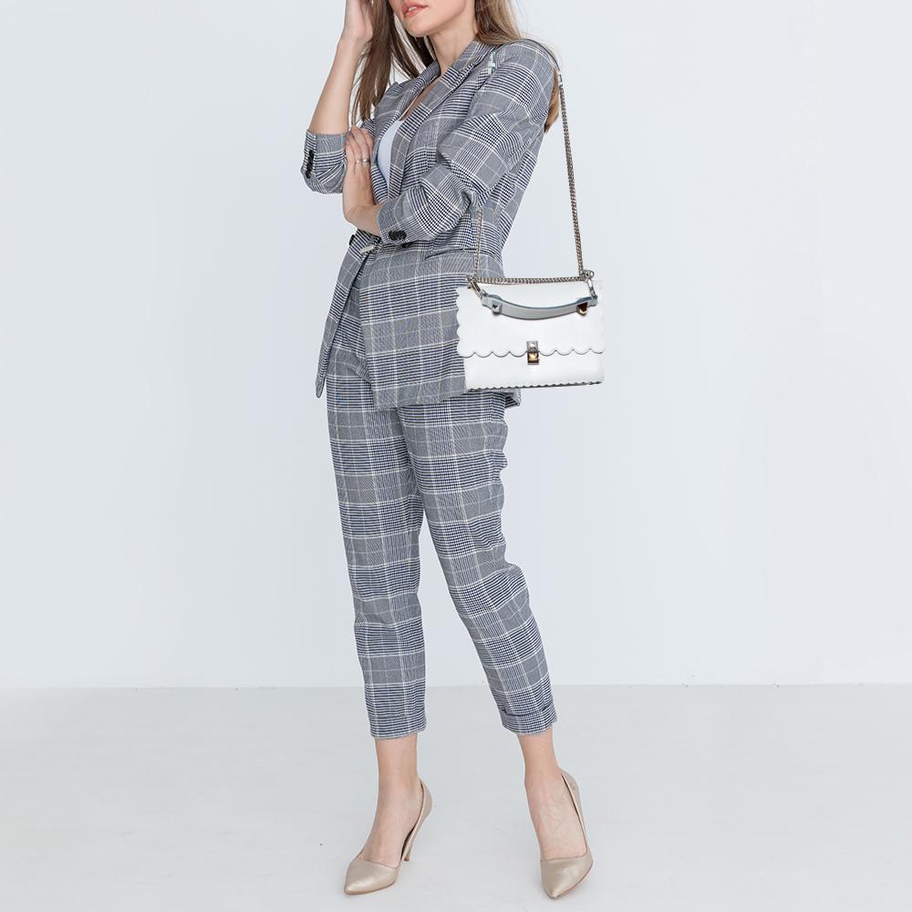 This stunning Kan I bag by Fendi has been crafted in Italy and will elevate your look instantly. It is made of leather and comes in a white hue. With a sturdy silhouette, this bag is adorned with scalloped edges. The studded lock opens to reveal a