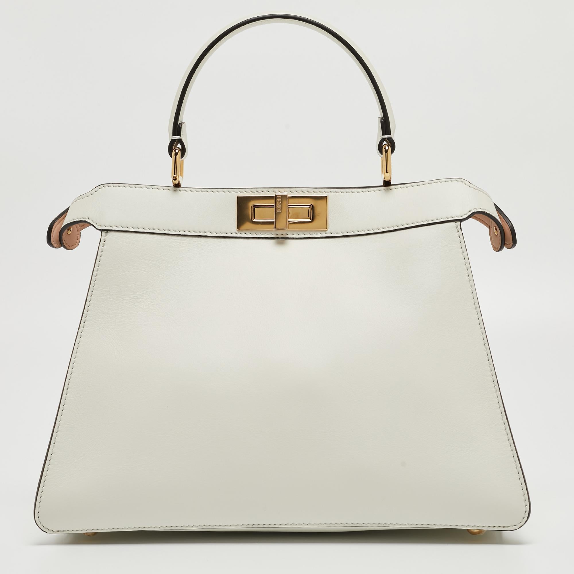 The Fendi Peekaboo ISeeU Top Handle Bag epitomizes luxury with its leather and iconic peekaboo design. The intricate inlay detailing adds a touch of sophistication, while the top handle offers a classic yet modern allure. This medium-sized