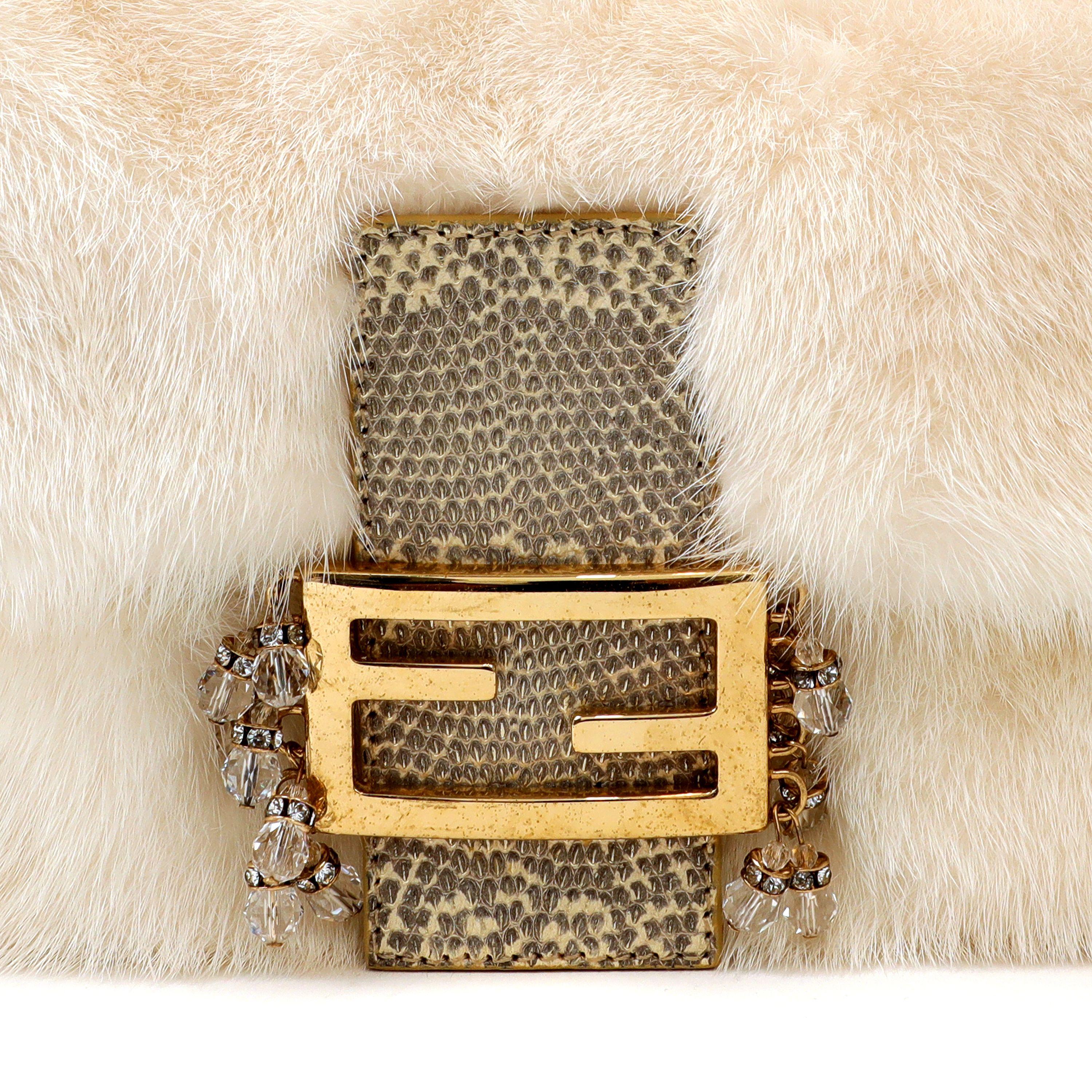 This authentic Fendi White Mink Baguette is in excellent condition.  An exotic version of the iconic Baguette, it features snowy white mink fur with gold hardware.  The Fendi logo clasp is embellished with ombre lizard skin and crystals.  Dust bag