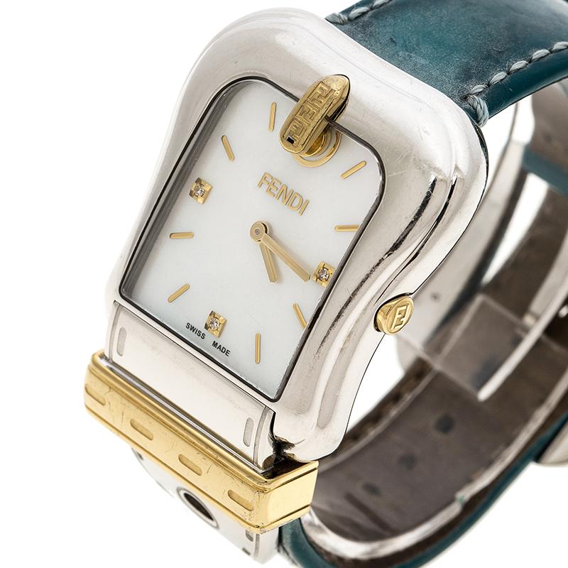 Fendi's B.Fendi style watch is a gorgeous creation from the house with a white stainless steel body and a case diameter of 33mm. It features a buckle-shaped, mother of pearl dial with gold-plated steel accents, diamond-embedded markers and gold-tone