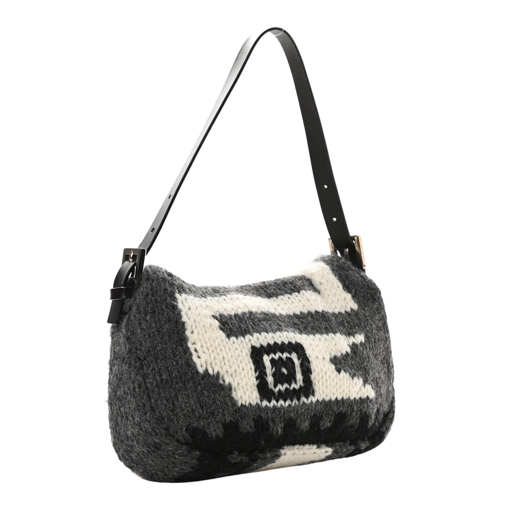 This baguette is made of black and white knit wool. The bag features a black leather shoulder strap, a frontal flap with polished dark silver Fendi FF magnetic snap closure. This opens to a pink satin interior with a zipper pocket.

COLOR: Black /