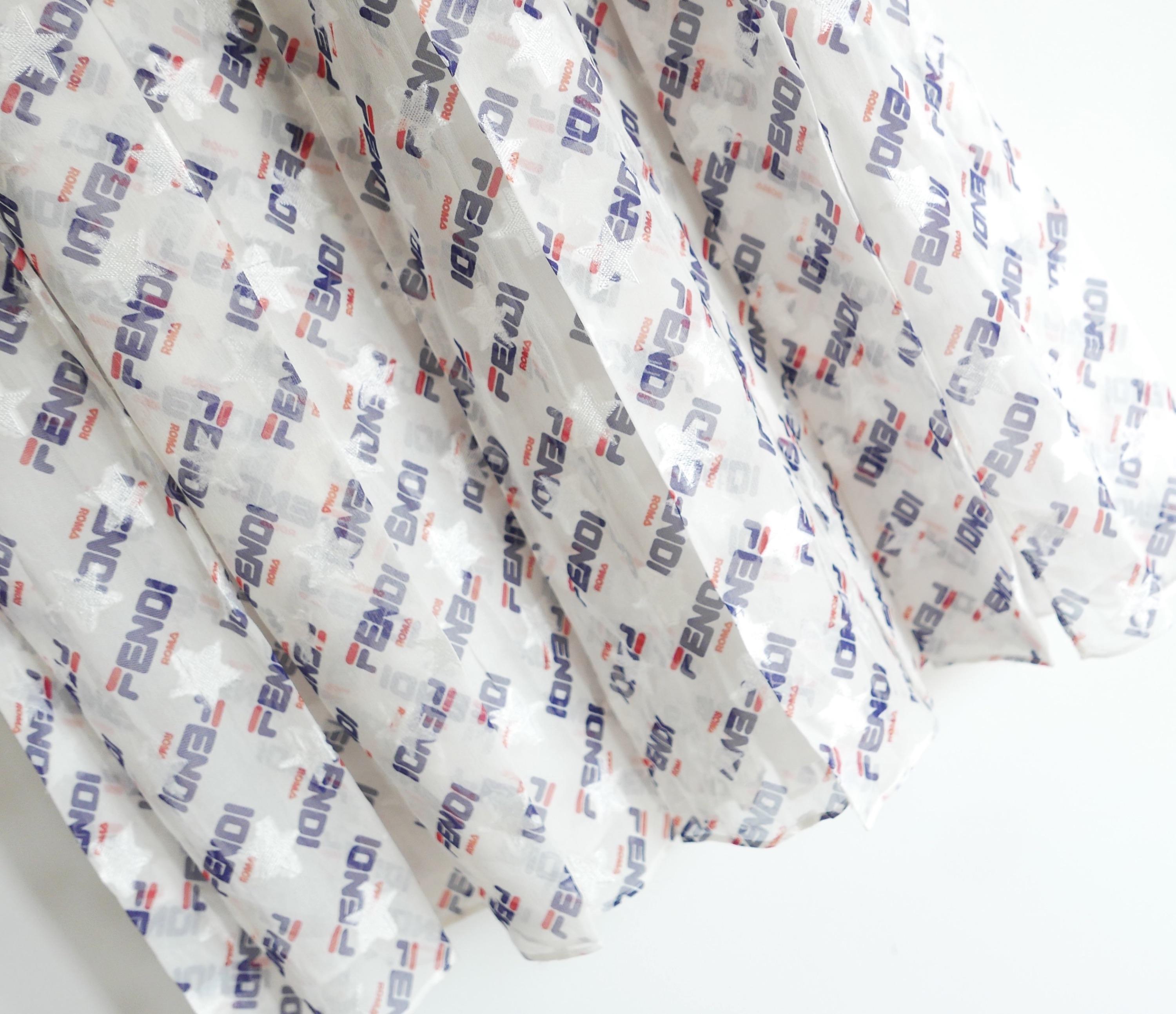 Fabuleuse jupe plissée à logo en édition limitée Fendi x Fila, issue de la collection capsule Fendimania 2018, achetée 1 450 € et non portée. Confectionnée en mousseline de soie mélangée jacquard étoilé et douce, elle arbore le logo Fendi dans le
