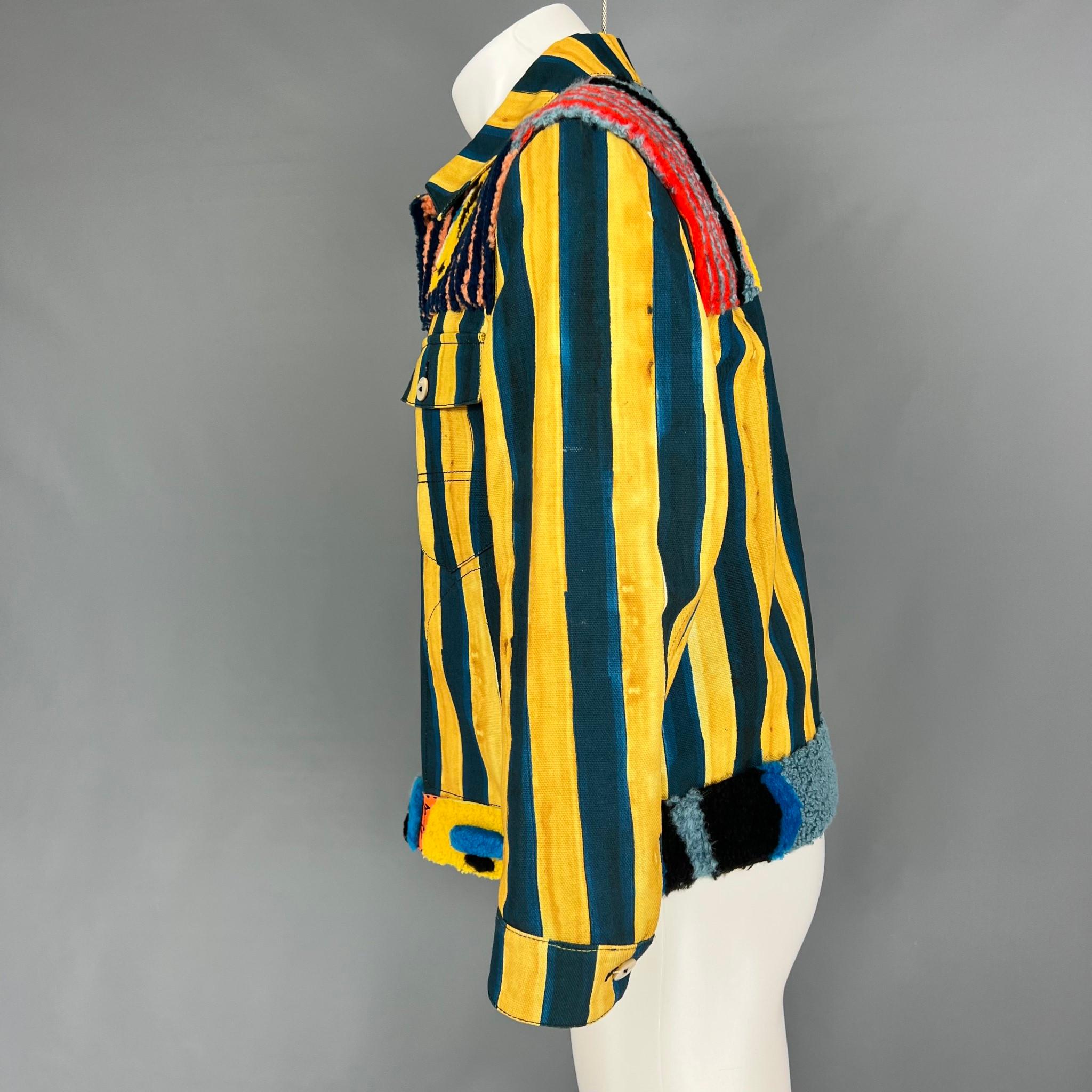 Fendi 'John Booth' artist collaboration whimsical cotton denim trucker Jacket from the Spring 2017 menswear presentation, features a spread collar, front button closure, long sleeves, buttoned cuffs, two chest pockets, a blue and yellow stripe print