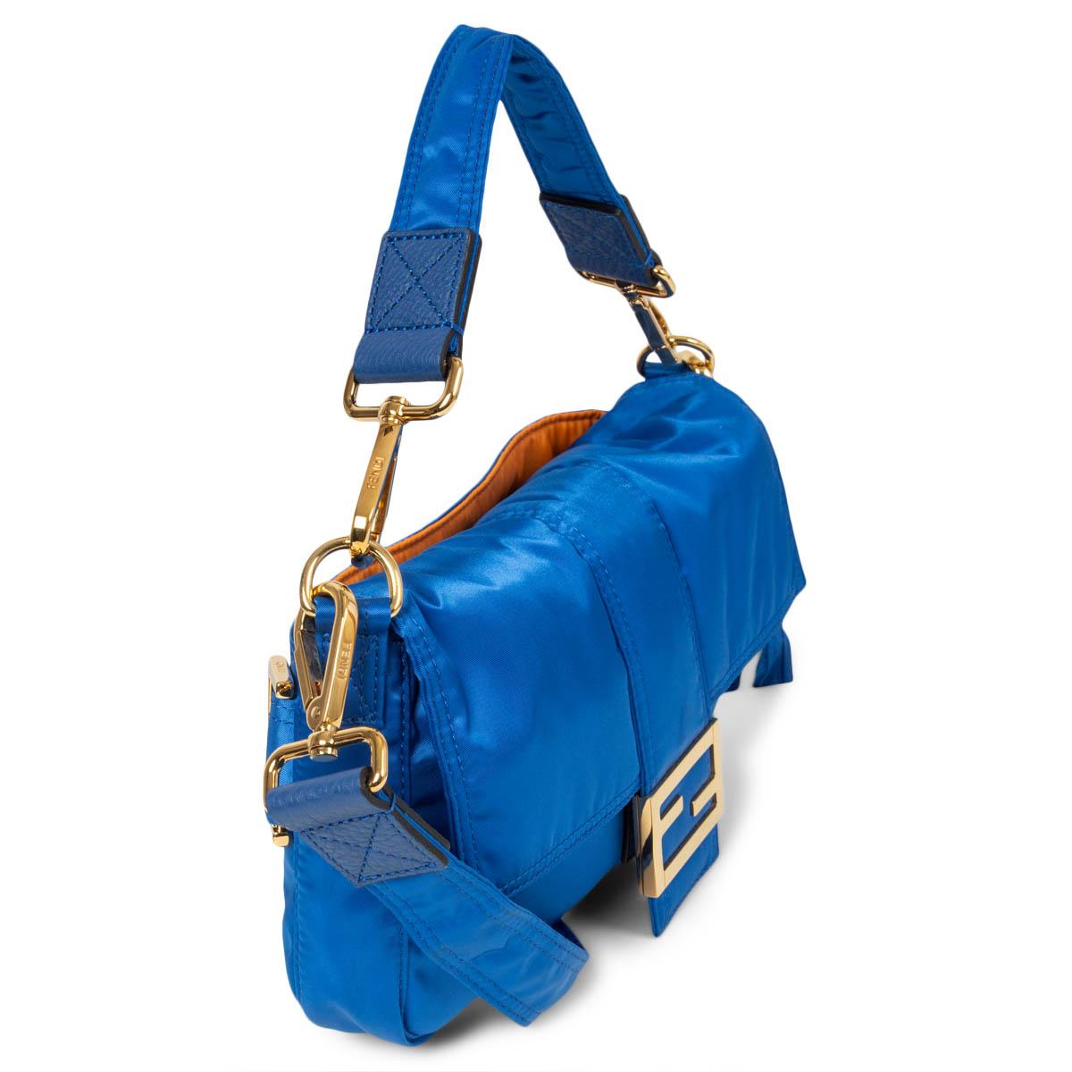 100% authentic Fendi x Porter Baguette Bag Capsule Collection in electric blue nylon featuring gold-tone hardware and leather details. Opens with a magnetic button under the flap and is lined in blue nylon with a zipper pocket against the back. The