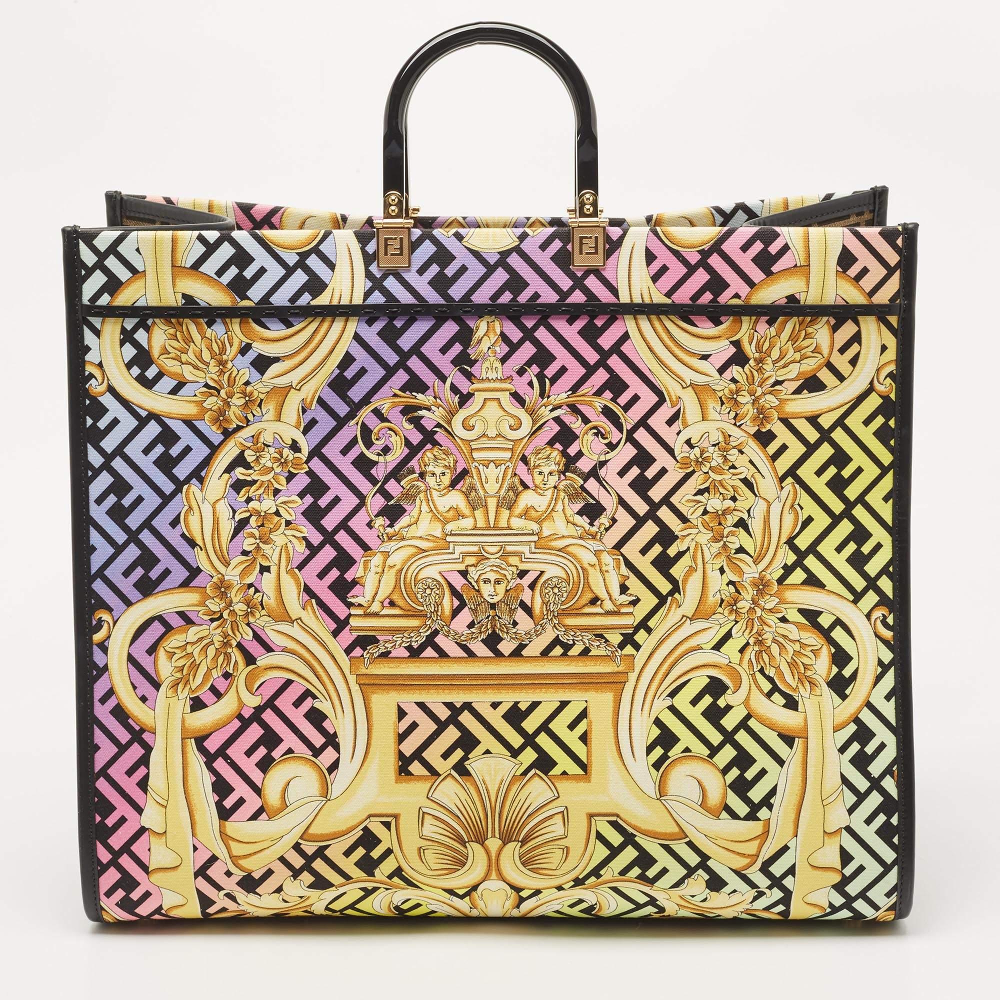 The Fendi x Versace Fendace Sunshine Tote is a stunning and vibrant accessory that showcases the fusion of two iconic fashion houses. This spacious tote features a lively baroque print on durable canvas, accented with luxurious leather details,