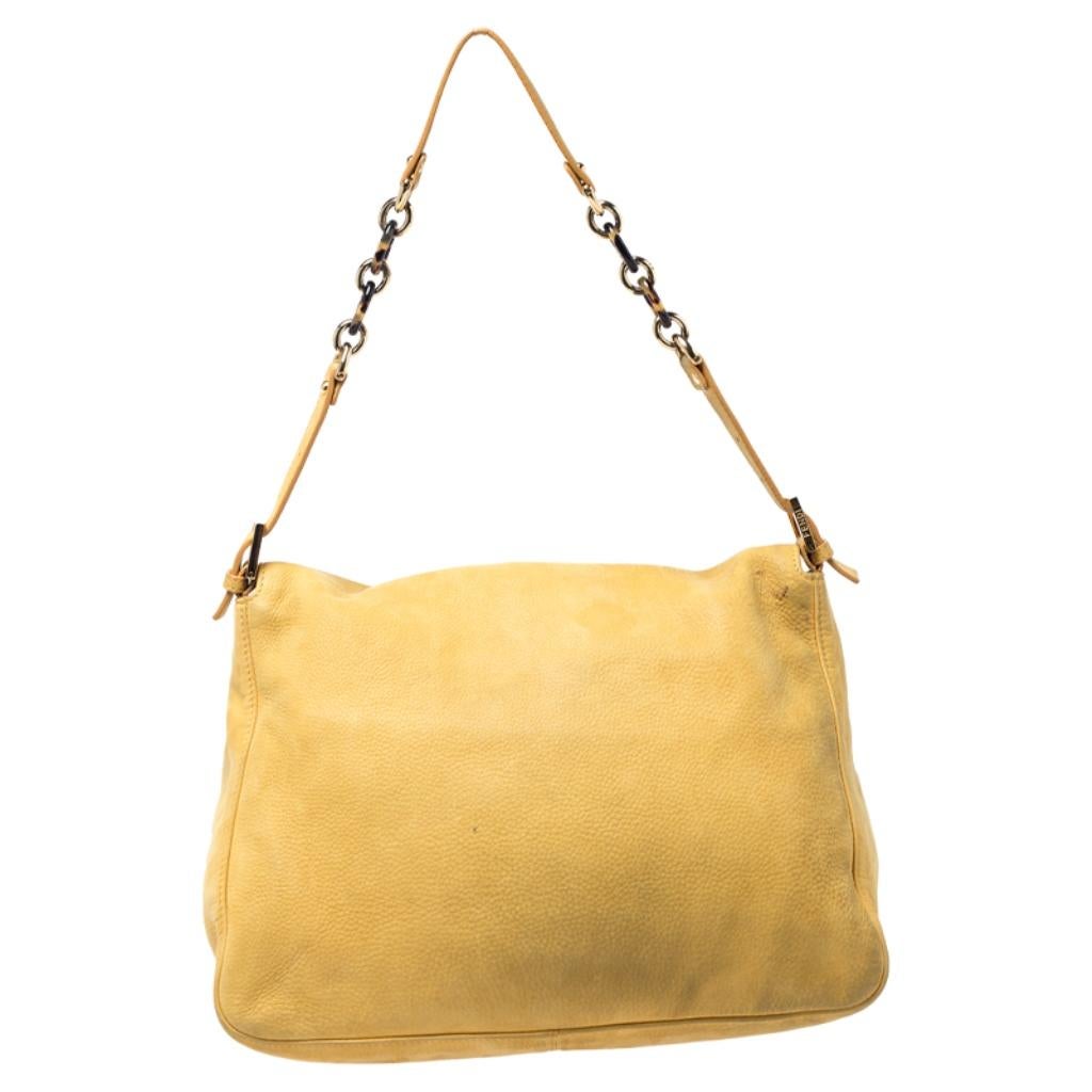 The Mama Forever shoulder bag from Fendi is a classic fashion choice. Detailed with their logo lock on the flap, this yellow leather piece is simple and stylish. A well-sized fabric interior and a leather and chain handle complete the
