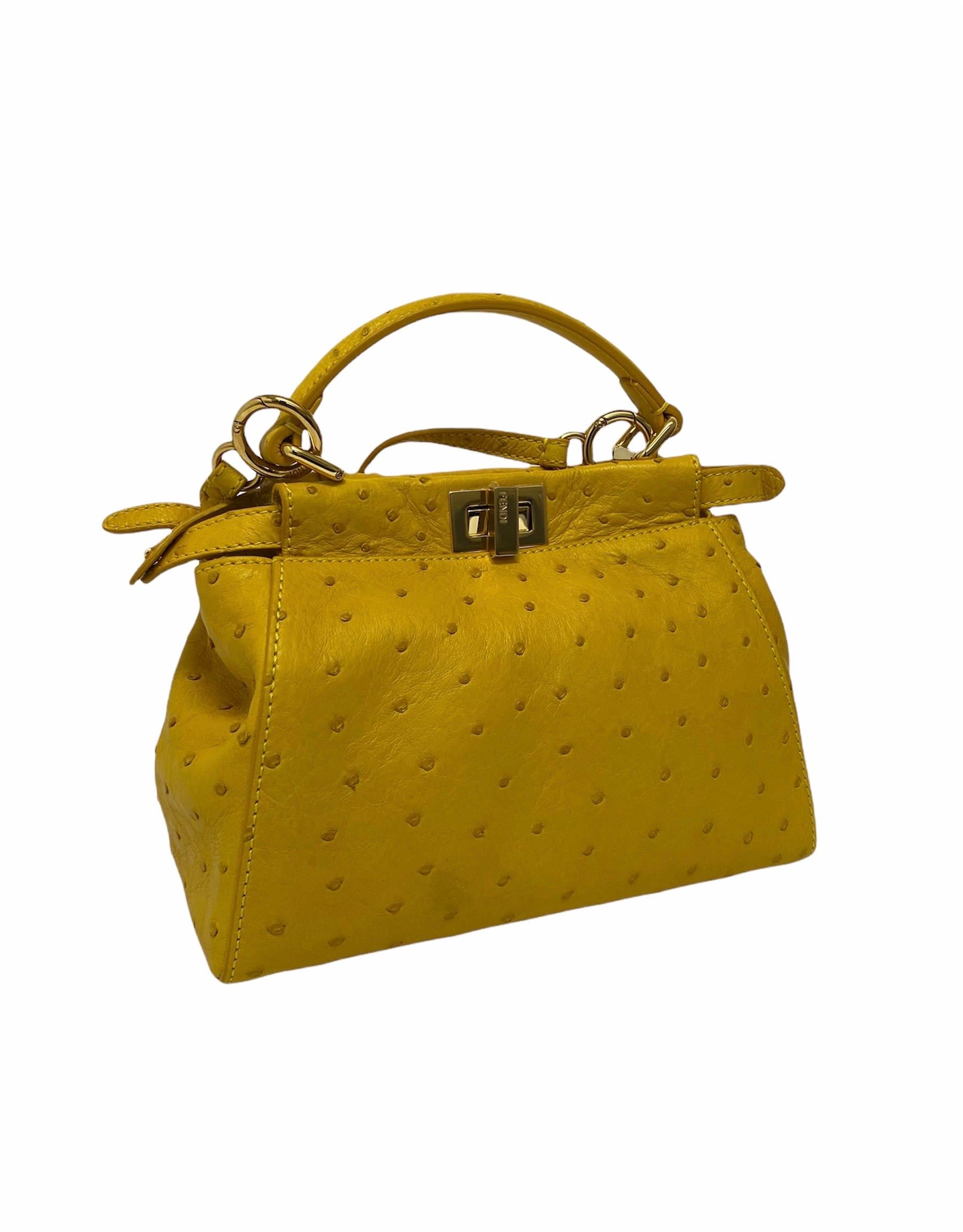 Fendi Peekaboo model bag made of yellow ostrich leather with golden hardware. Closure with hook, internally quite large and equipped with pockets. Equipped with leather handle and removable shoulder strap. The bag is in like new condition.