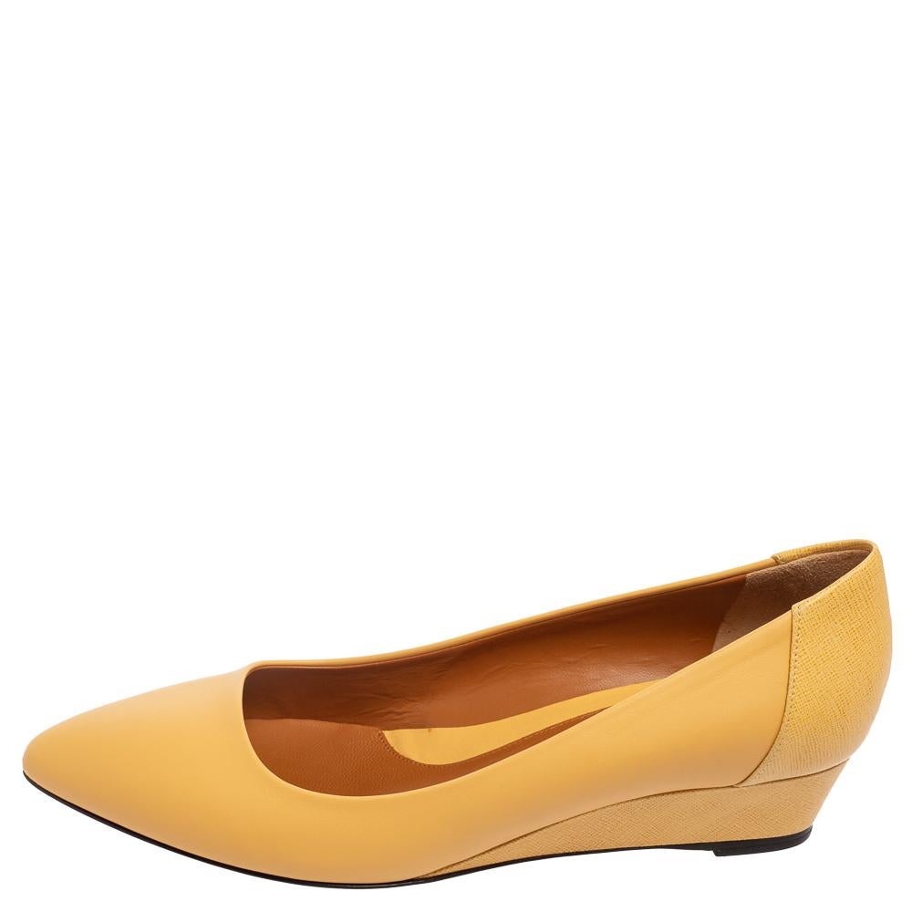 Flaunting a classic silhouette and durable construction, this pair of pumps by Fendi is fitting for everyday use. This pair of yellow leather pumps has pointed toes and low wedge heels.

Includes: Info Booklet, Original Box