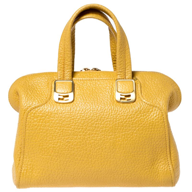 You will love to carry your essentials in this stylish Fendi Chameleon satchel. Crafted from beautiful yellow leather, the bag is provided with gold-tone hardware. It features two flat handles and one adjustable shoulder strap, which are accented