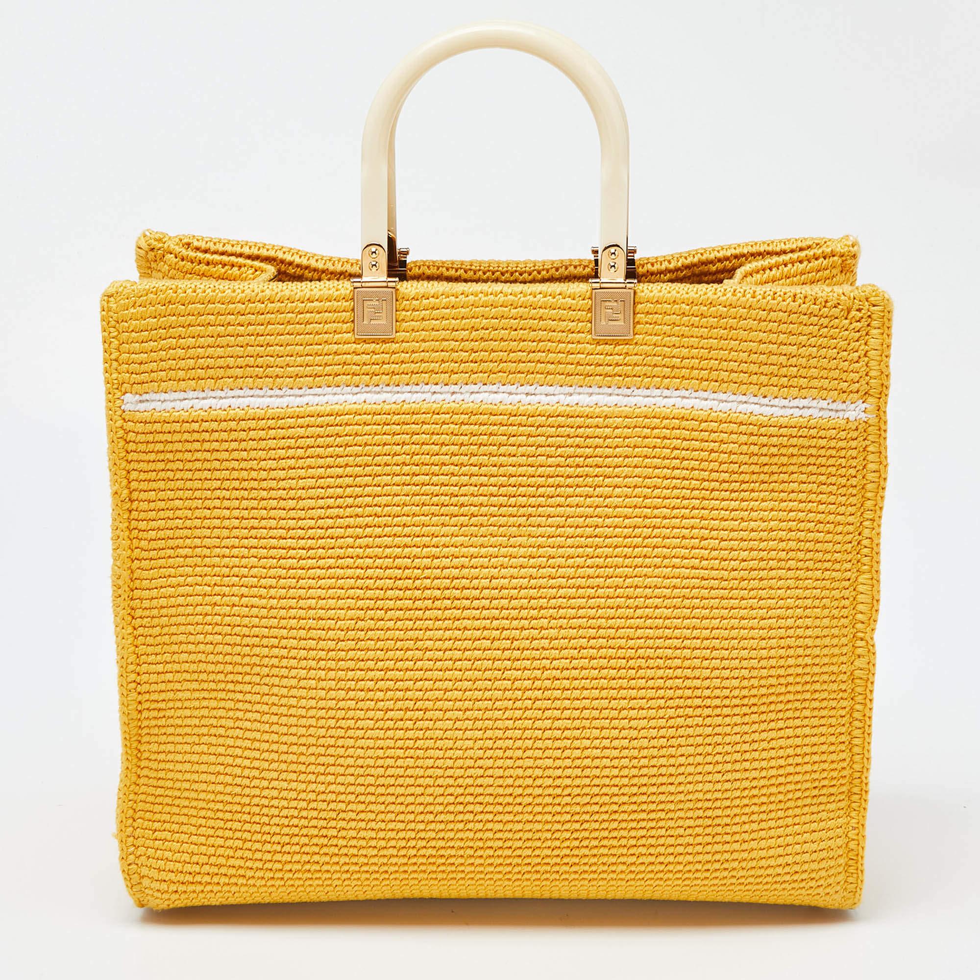 The Fendi Sunshine Tote is a luxurious and versatile handbag. Crafted from supple crochet and leather, it features a spacious interior. The iconic Fendi logo is on the front, and the bag is adorned with elegant gold-tone hardware. A detachable