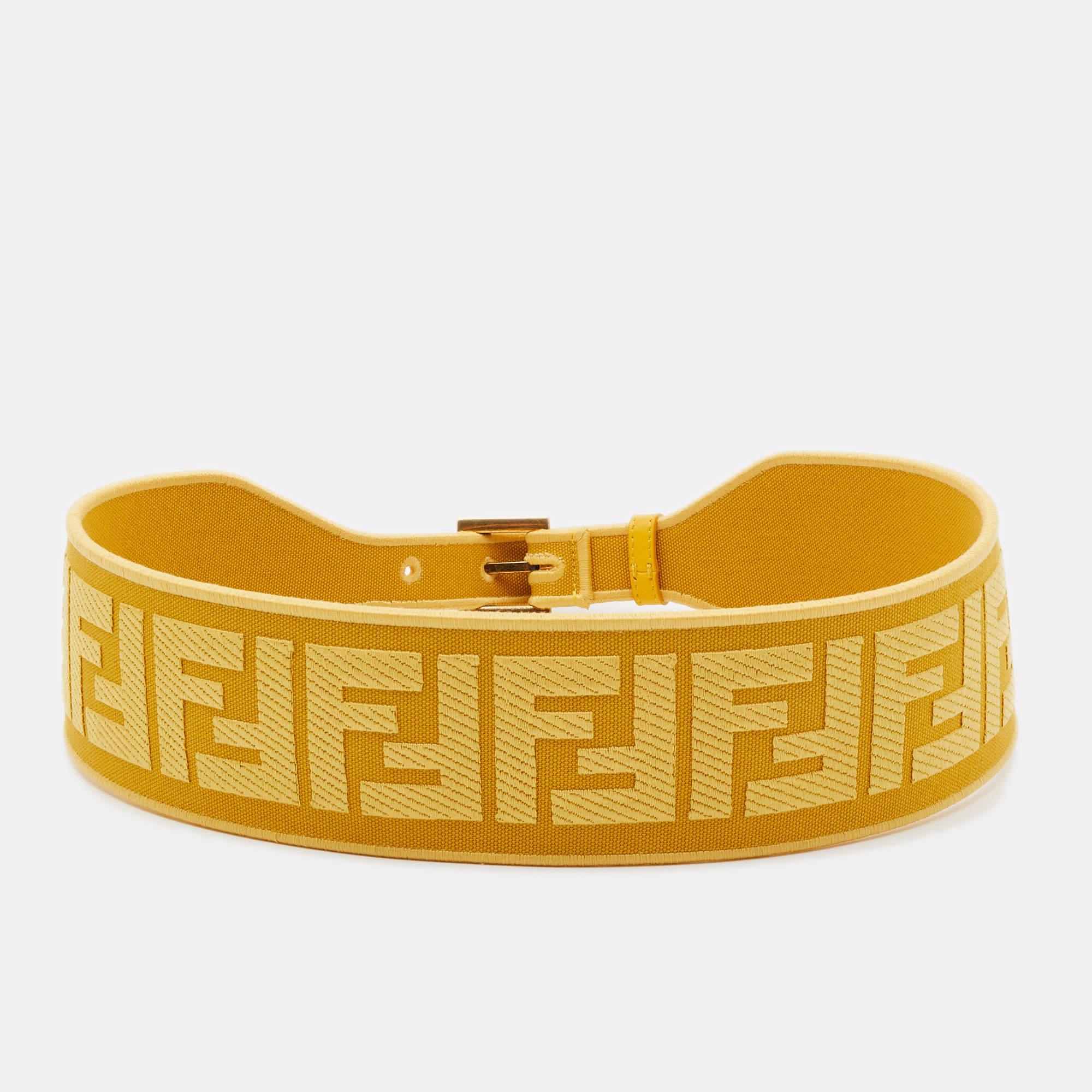 The Fendi belt is a luxurious fashion accessory. It features Fendi's iconic Zucca logo pattern in yellow on jacquard fabric. The belt is designed to cinch the waist, and it's adorned with a stylish buckle, adding a touch of elegance to any