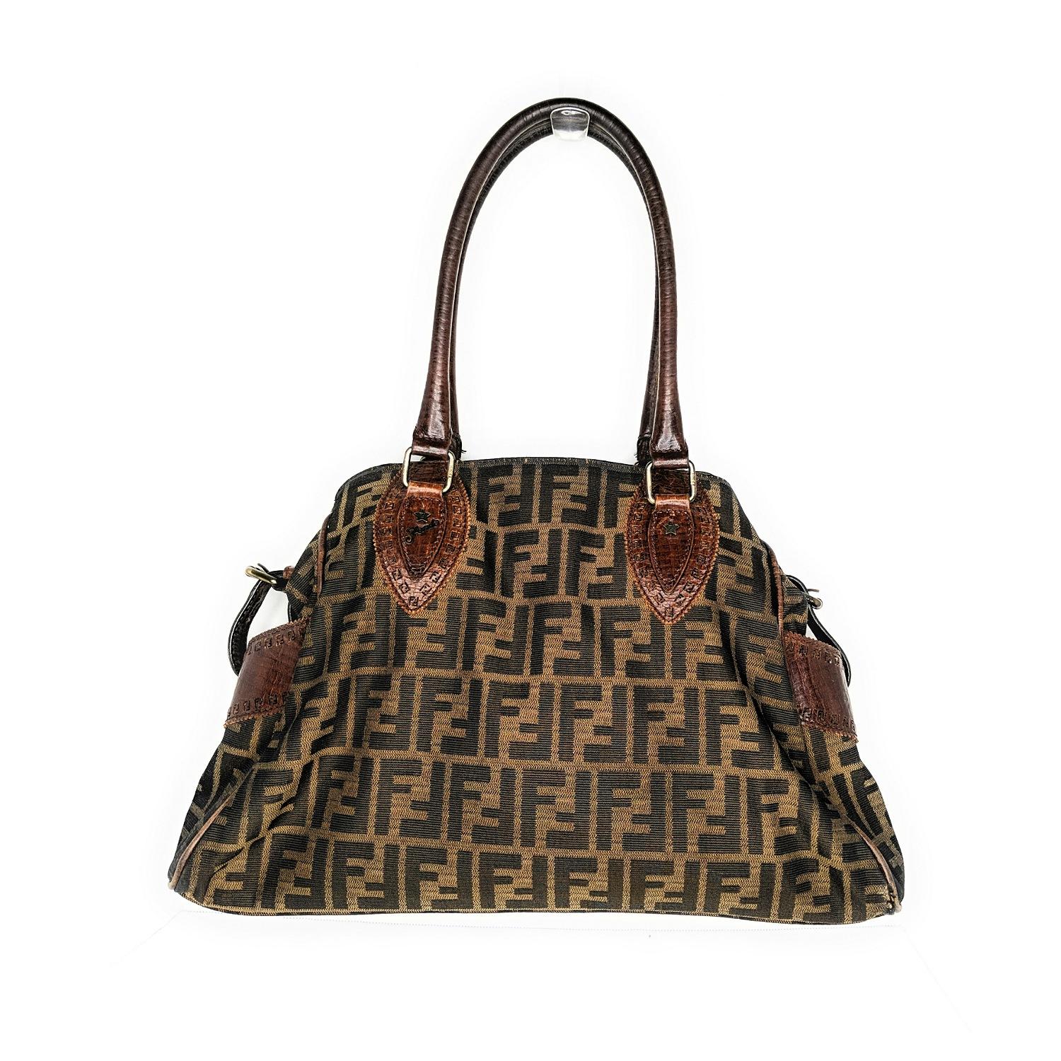 Die elegante Form und der Druck der Fendi Zucca du Jour machen sie zu einer klassischen Handtasche. Die Tasche ist aus dem ikonischen Zucca-Canvas von Fendi gefertigt und verfügt über Seitentaschen:: Lederbesatz und Doppelgriffe. Der