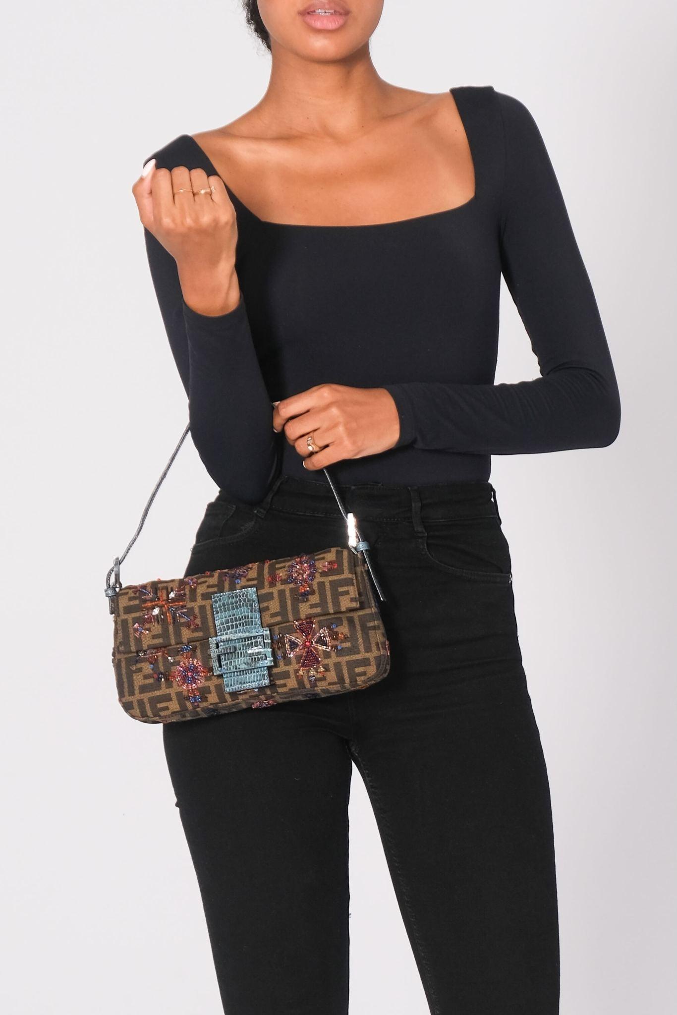 This bag is made of a brown Fendi monogram canvas and has embroidered flowers throughout. The bag features an adjustable blue lizard shoulder strap and a unique lizard Fendi logo snap that opens to a blue satin interior.  Vintage.

Color: brown with
