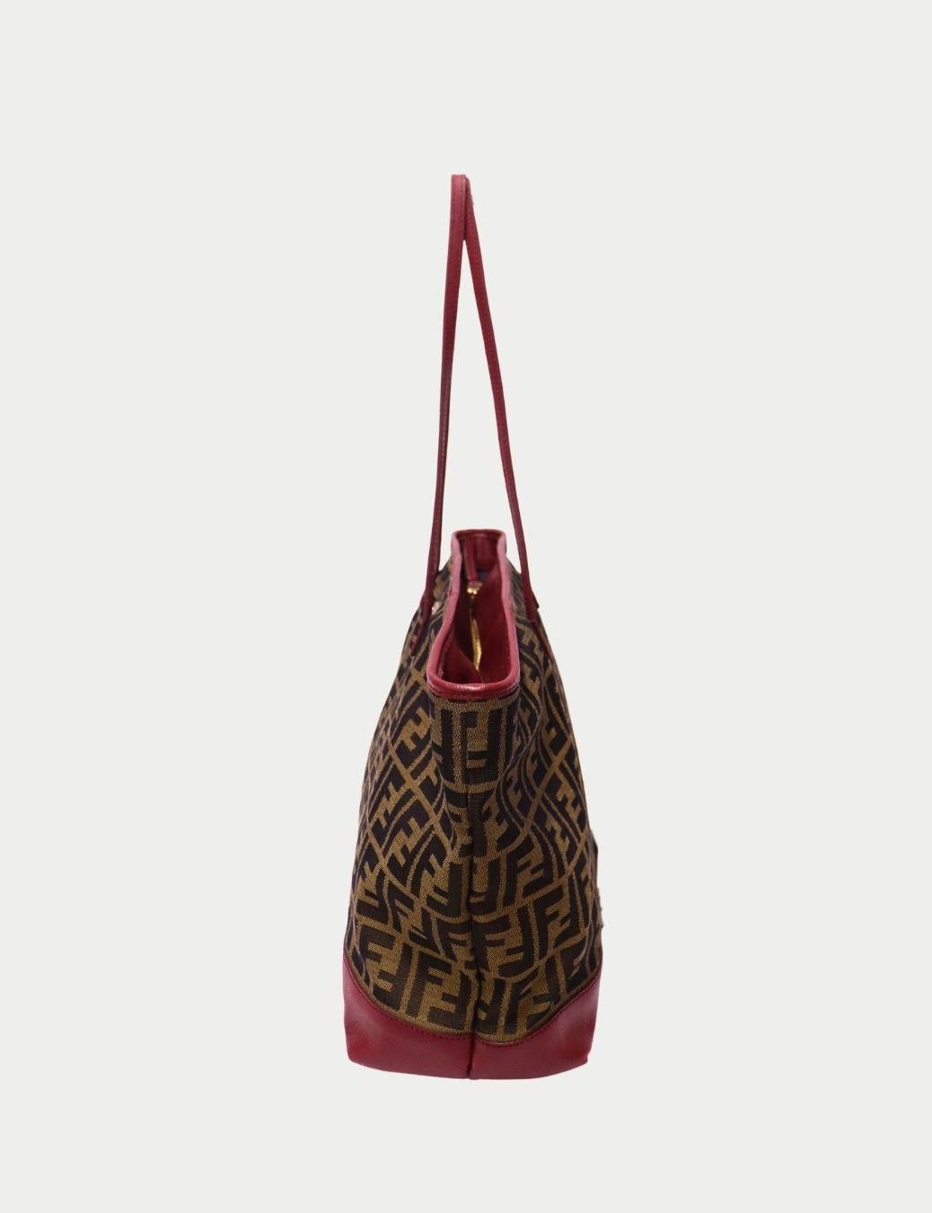 Fendi - Fourre-tout en toile Zucca avec bordure en cuir rouge

Entrez dans le luxe italien intemporel avec ce sac fourre-tout en toile Icone de Fendi, orné du monogramme FF emblématique de la maison et d'une élégante bordure en cuir rouge. Mélange