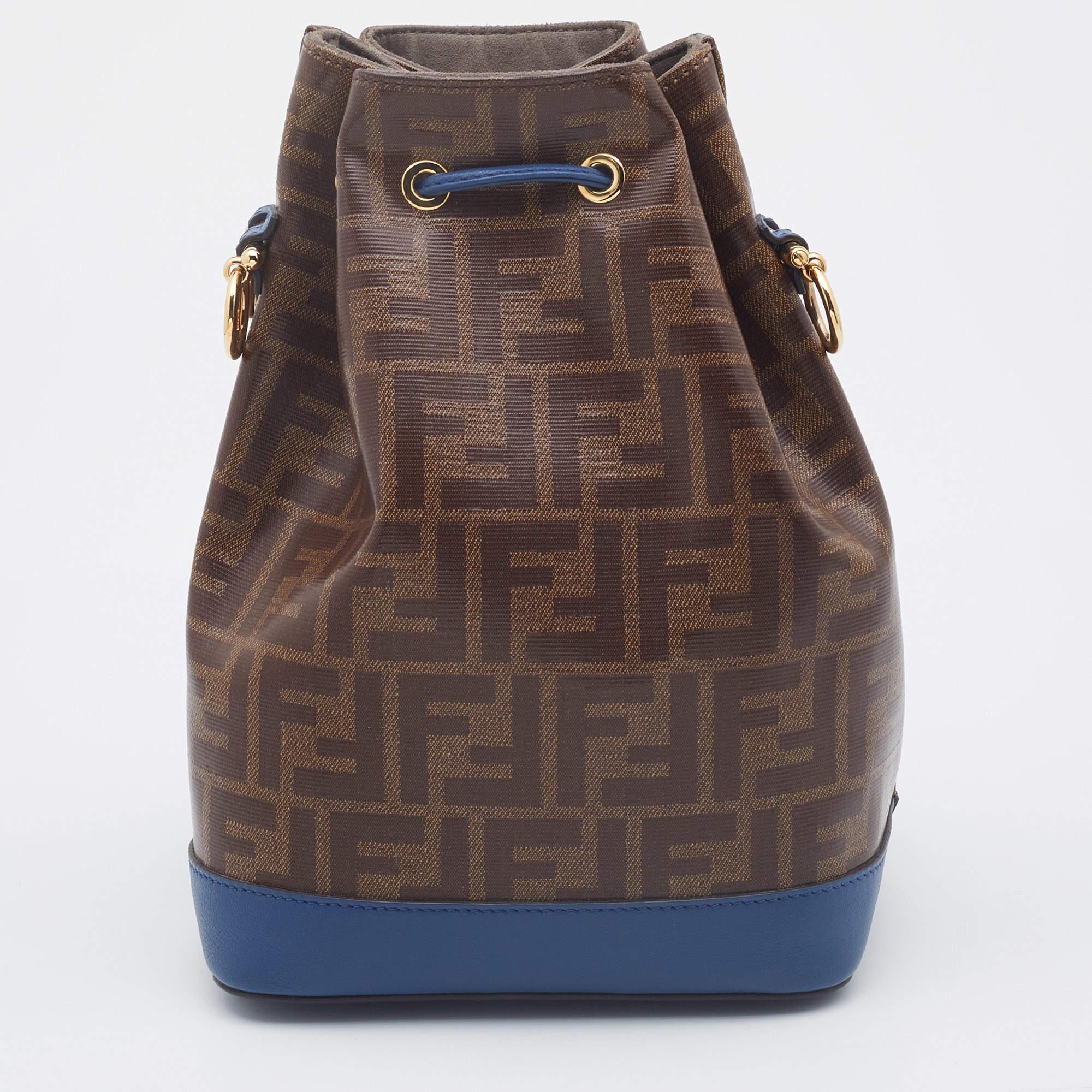 This wonderful Fendi Mon Tresor Grande design is made from Zucca-coated canvas, leather, and gold-tone hardware. The bag has a bucket shape with a drawstring closure that secures the interior. It is complete with a shoulder strap. It is an apt