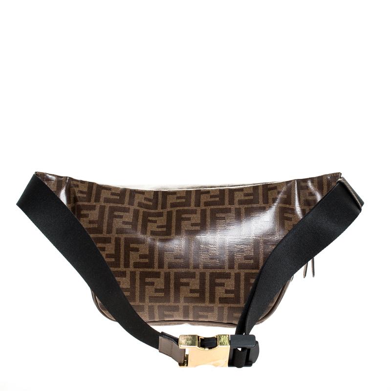 This belt bag from Fendi has been crafted using Zucca coated canvas for you. It is stylish and extremely well-made. It has a fabric interior for your belongings and a belt with a safety buckle. You can wear it on your waist or across your
