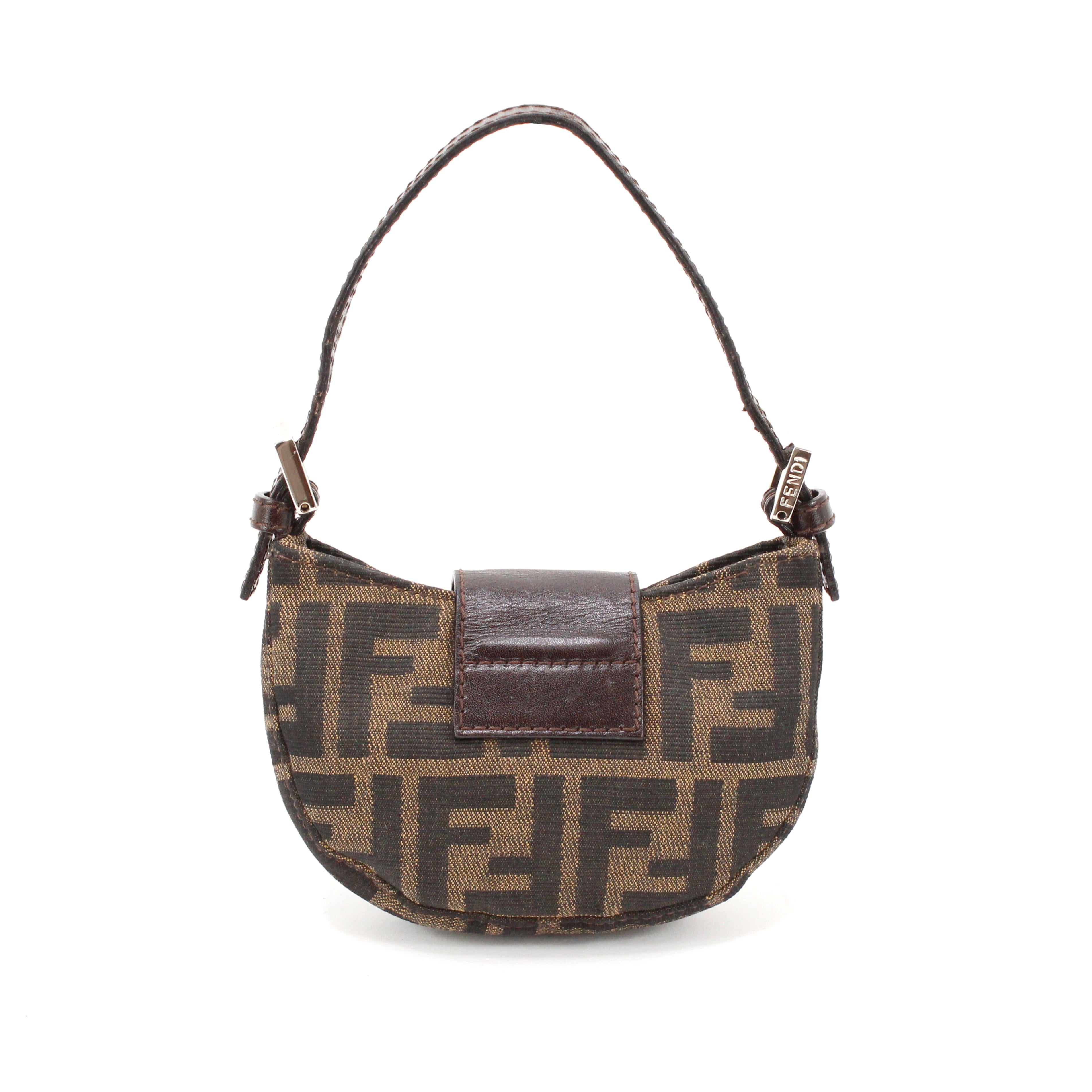 Fendi baguette croissant in brown zucca monogram canvas + brown leather, silver hardware.

Condition: 
Excellent.

Packing/accessories:
Dustbag.

Measurements:
Width: 13 cm
Height: 8 cm