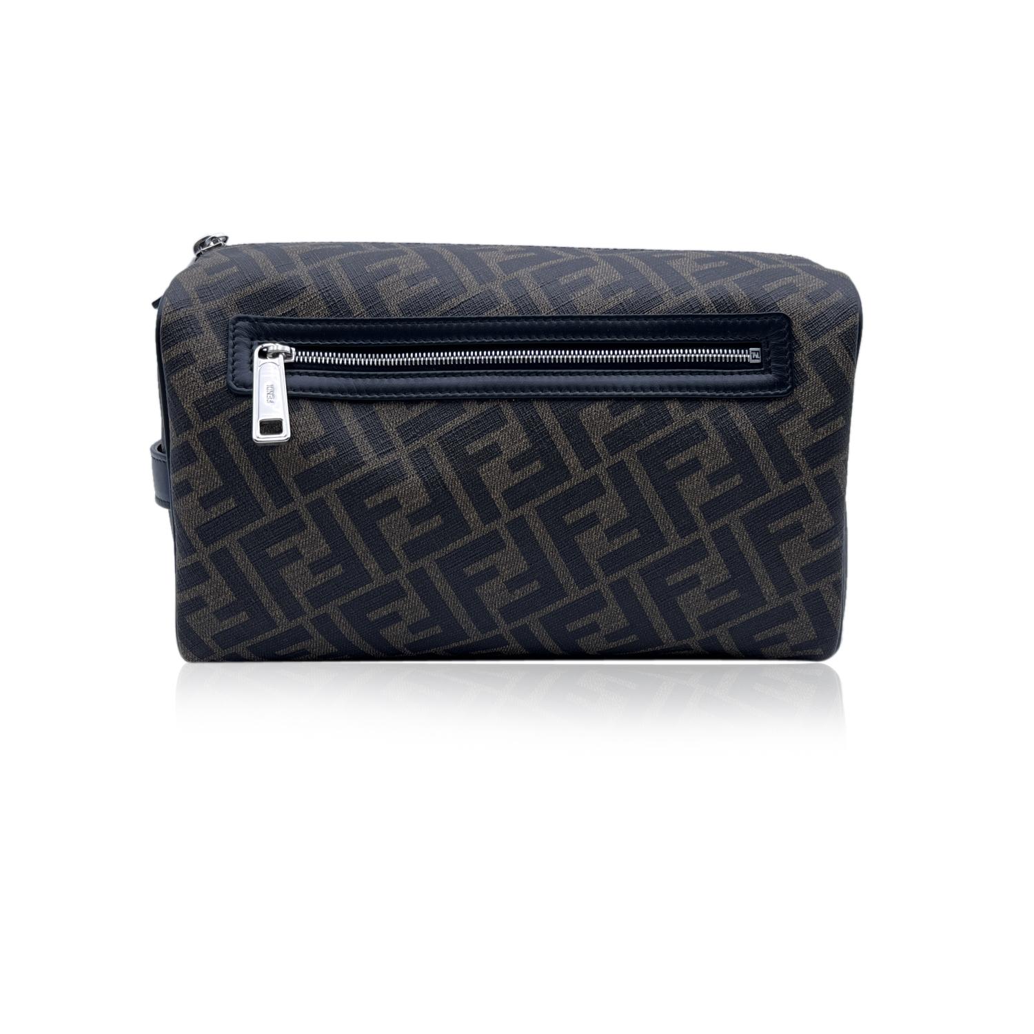 Fendi Travel cosmetic bag, crafted in brown Zucca canvas with black and brown leather trim. Black leather handle on a side. Upper zipper closure. 1 rear zip pocket. Black fabric lining. 1 side open pocket inside. 'FENDI - Made in Italy' tag inside,