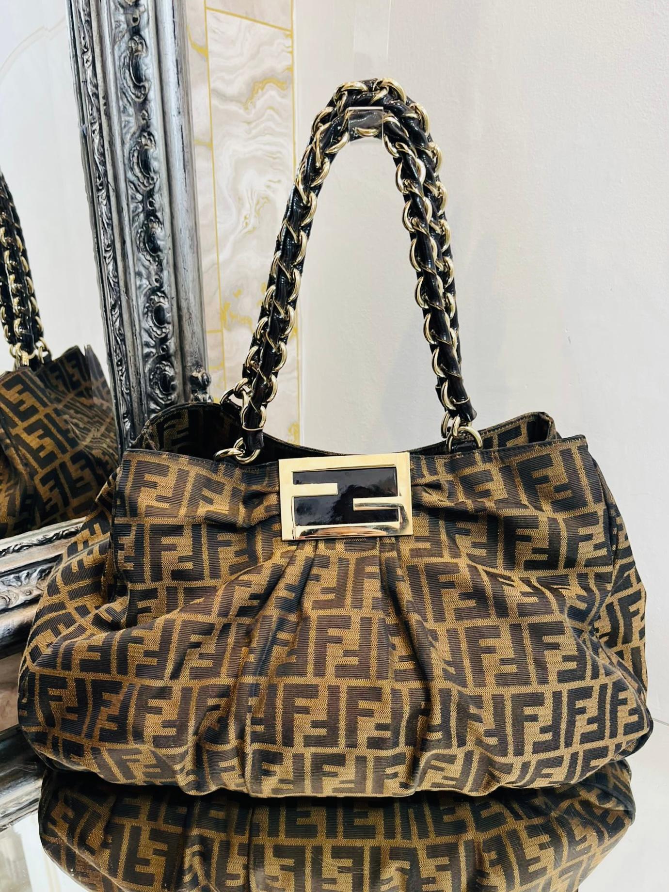 Fendi Zucca 'FF' Monogram Canvas Mia Agenello Bag

Logo printed soft body canvas bag with brown patent leather trim

and large Fendi 'FF' logo, gold plate on the front.

Chain and leather shoulder straps.

Size - Height 31cm, Width 44cm, Depth