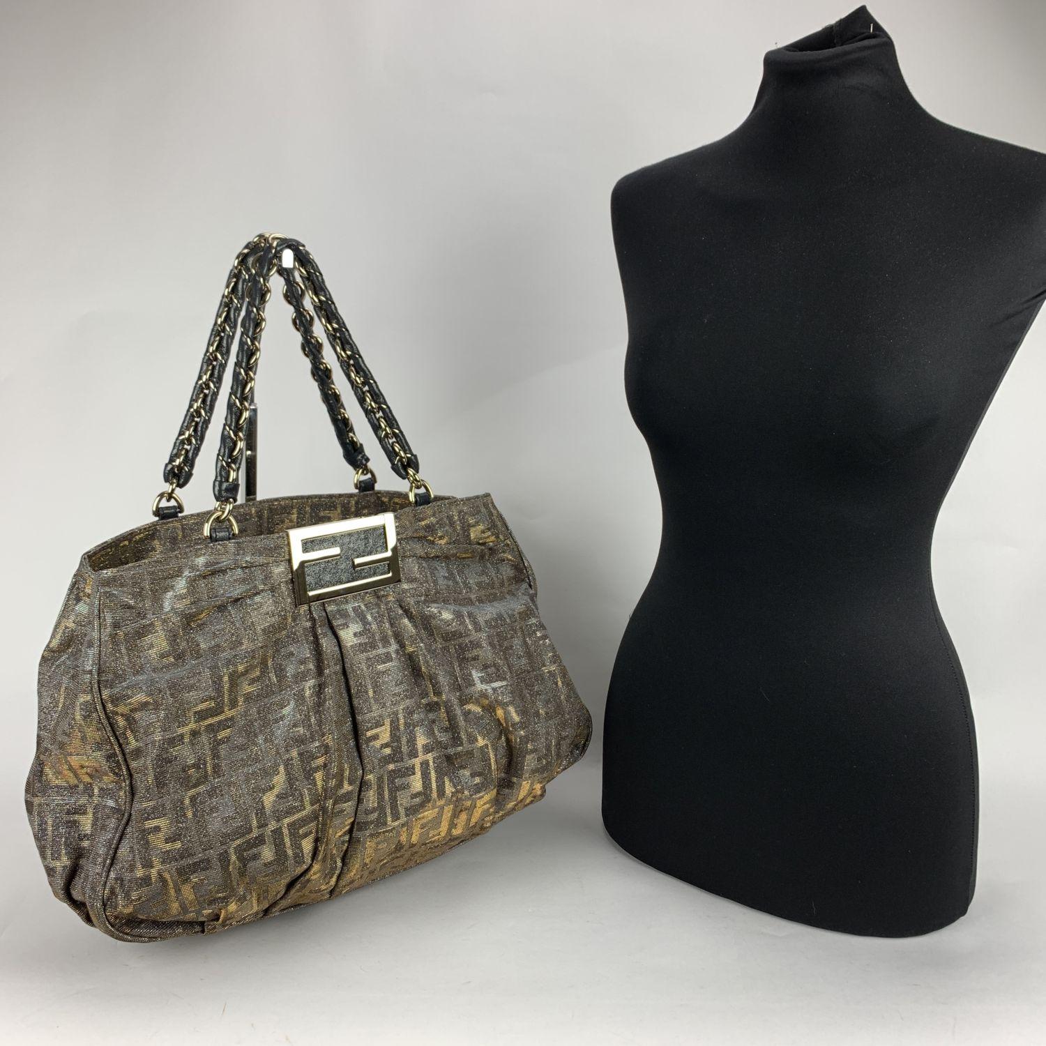 Beautiful Fendi 'Mia Chain' tote bag. Crafted of glittered Zucca FF monogram canvas with gold metal hardware. The bag has 2 chain-link handles. Open top. 2 main sections inside and 1 middle zip section. FF - FENDI logo in gold tone metal. Black