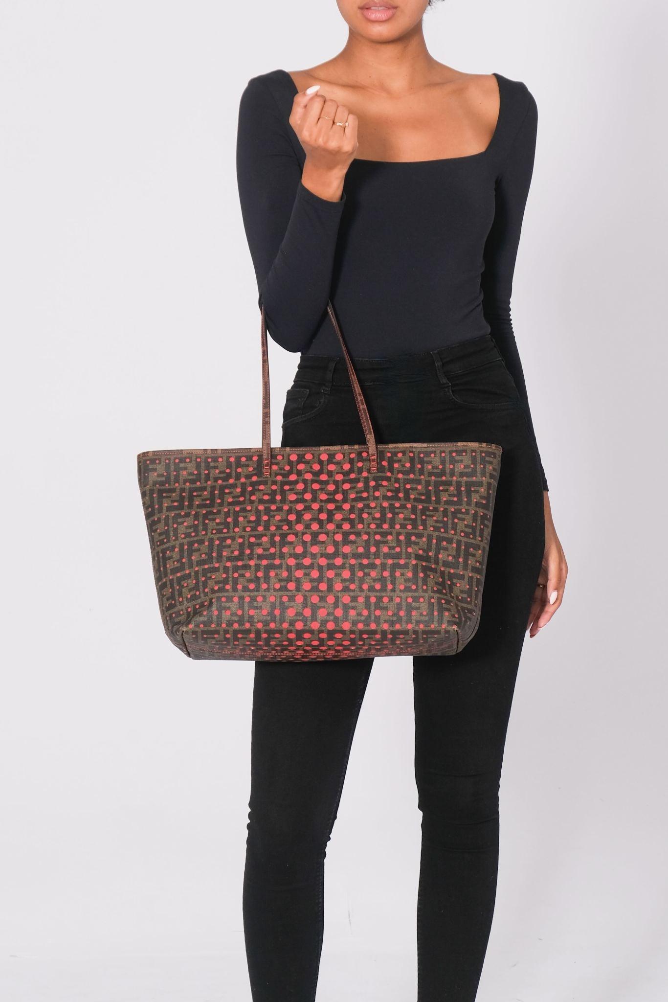 This tote is made of perforated Zucca FF monogram coated canvas. The tote features red stitching and matching strap handles. The top zipper opens to a red canvas interior with a zipper pocket. Retail.

Color: brown monogram FF and red
Material: