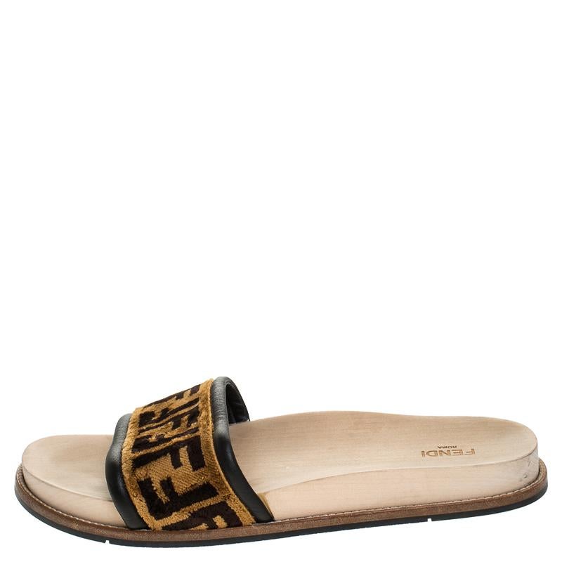Designed with open toes and the signature Zucca print on the vamps, these Fendi slides are simply awesome and stylish! They've been smartly crafted from velvet in a stunning brown hue. They are styled with wooden insoles and sturdy outsoles.

