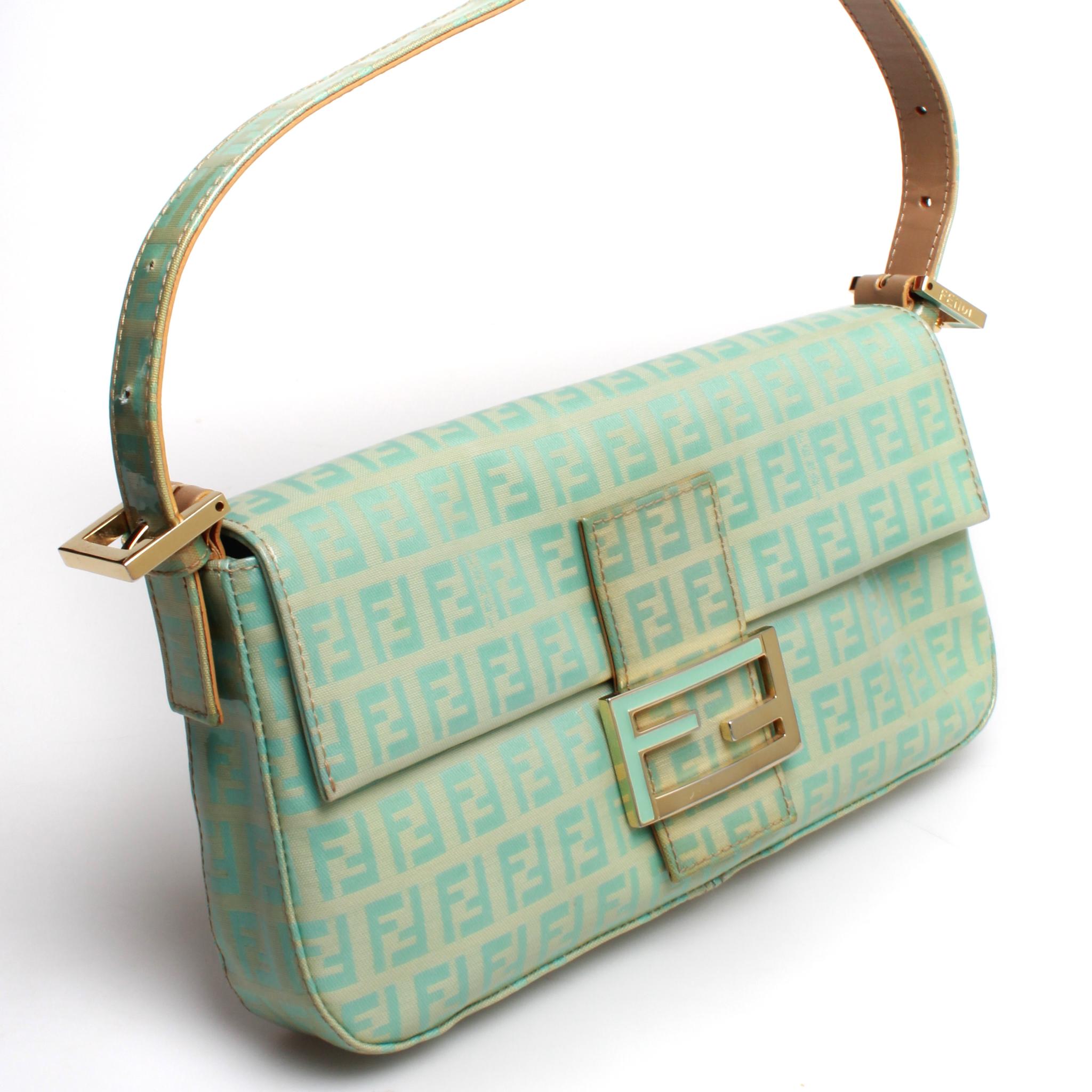 Teal and beige zucchino coated canvas Fendi baguette bag with gold toned hardware. Flat shoulder strap and single gold zip interior pocket. Comes with dust bag. Slight discoloration on front of bag consistent with age and vintage nature.