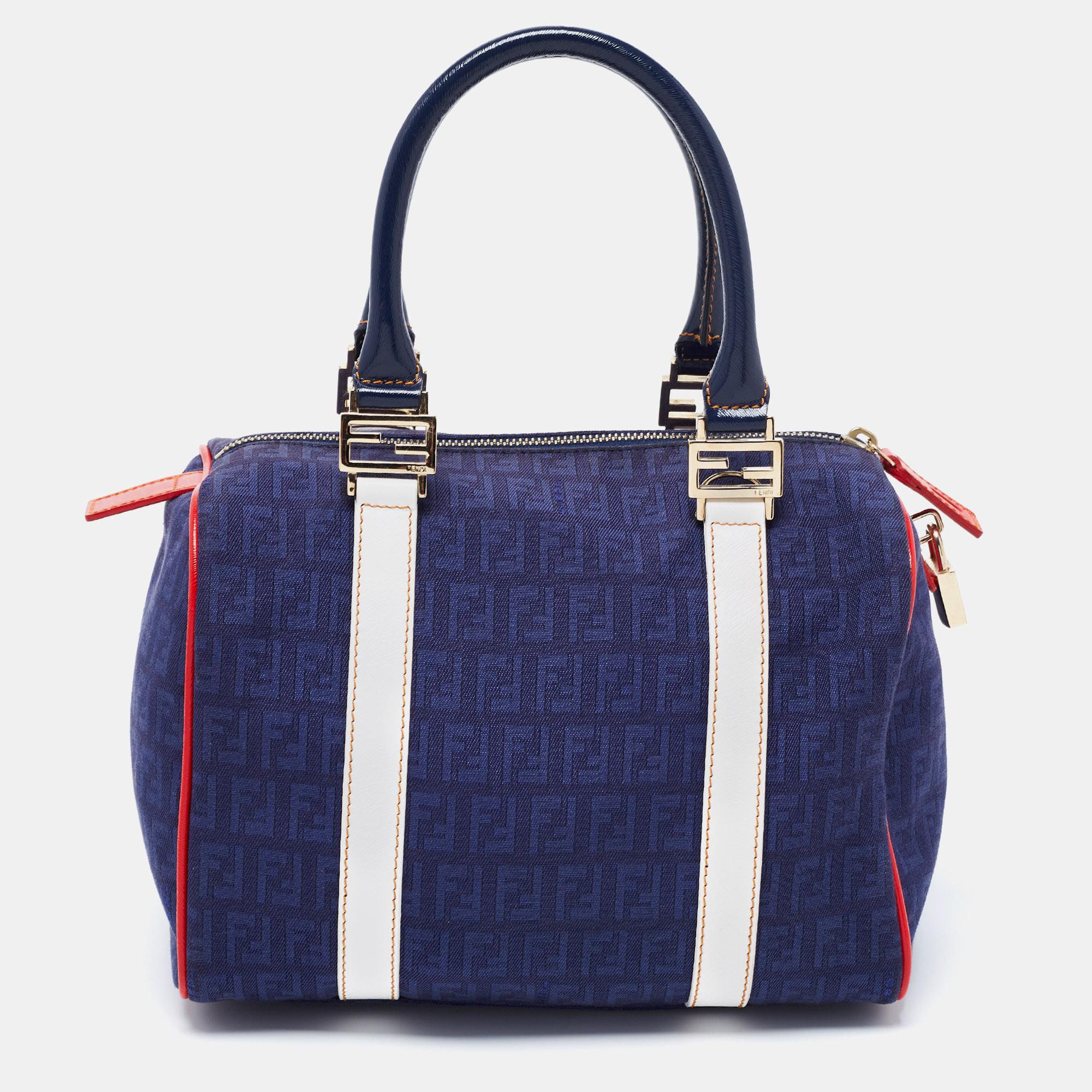 This elegant Forever Bauletto Boston bag from Fendi is crafted from Zucchino canvas and is perfect for daily use. The beautiful bag features splendid details in the form of multiple colors, patent leather trims, dual top handles, and a padlock. The