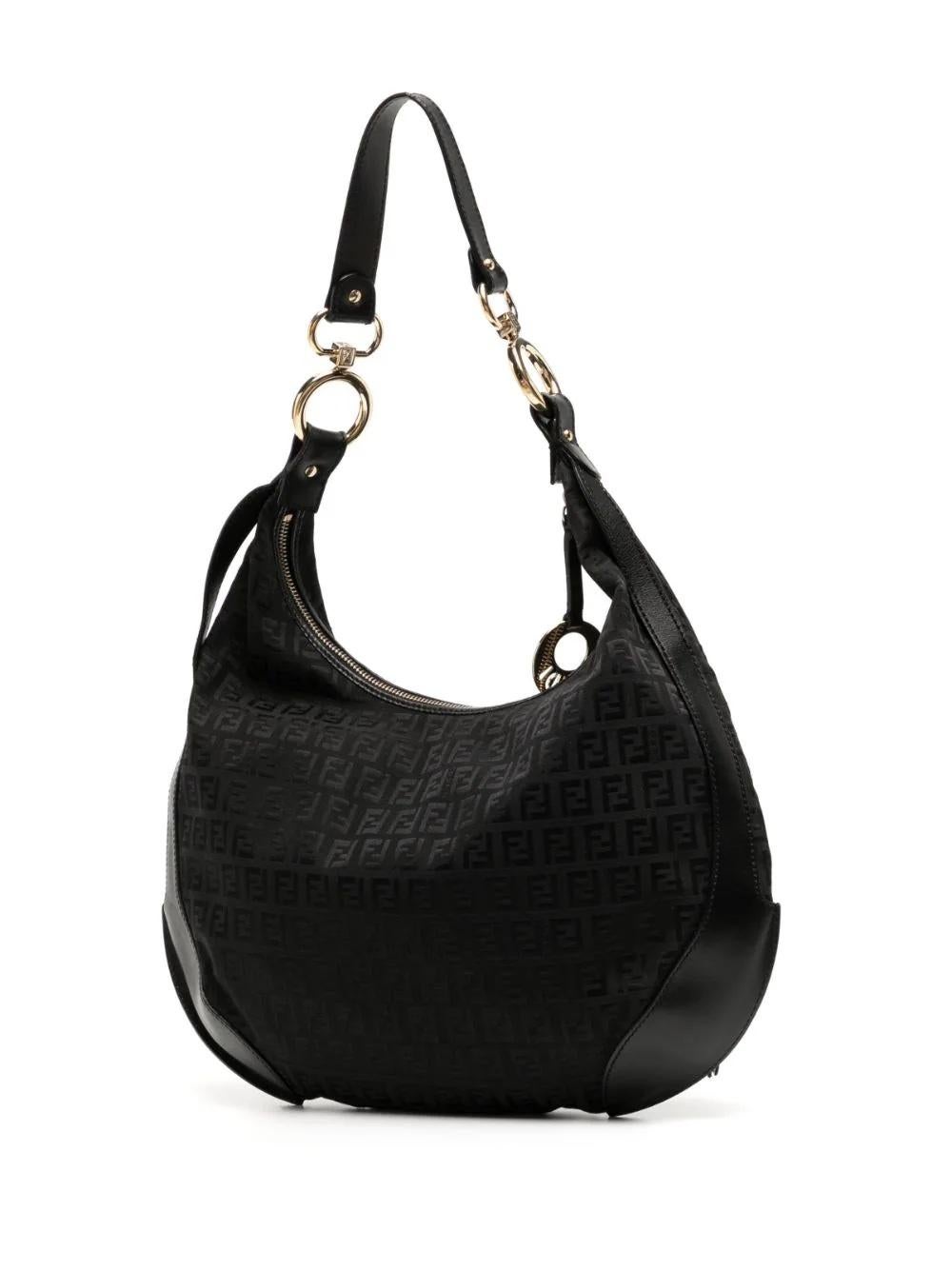 This distinctive Fendi Zucchino monogram pattern in canvas with leather details is present in this medium-sized hobo bag. Boasting a single shoulder strap, external pocket, golden logo charm, and golden hardware, it is both stylish and practical.