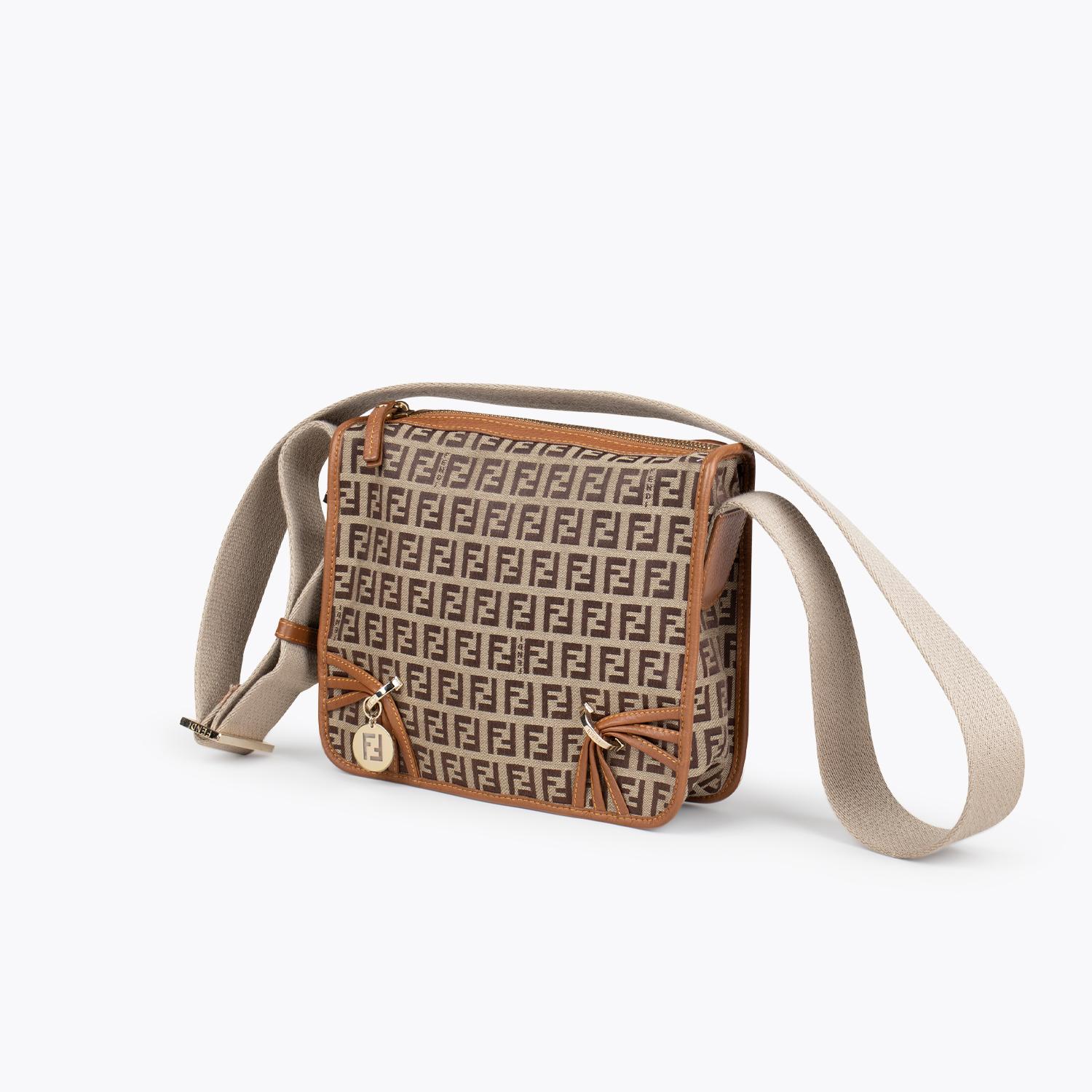 Fendi Leather-Trimmed Zucchino Crossbody Bag

- Fendi Crossbody Bag
- Neutrals
- Graphic Print
- Zucchino FF Logo
- Gold-Tone Hardware
- Single Adjustable Shoulder Strap
- Single interior Pocket
- Logo Jacquard Lining and Zip Closure at Top

Overall