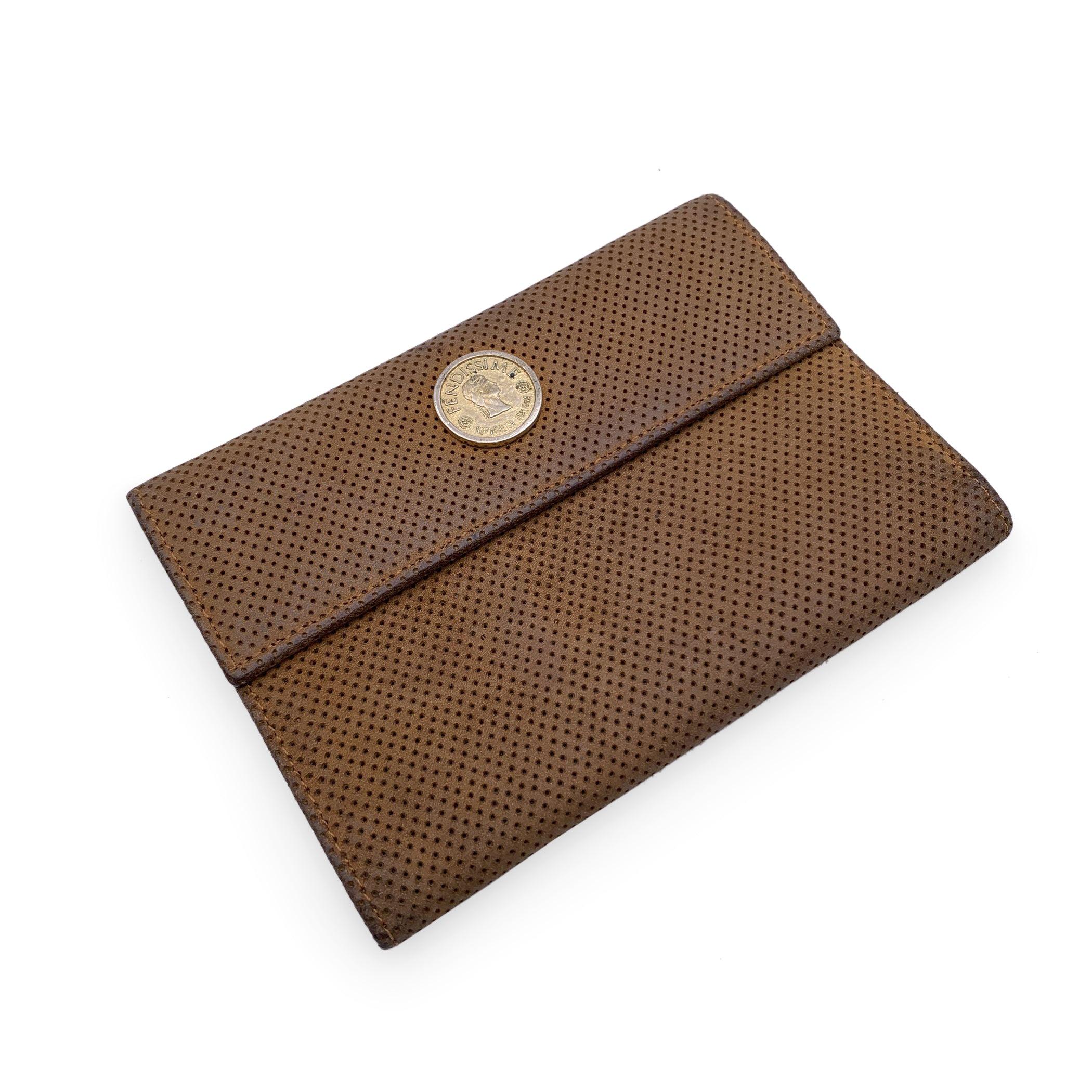 Vintage Fendissime wallet in beige perforated leather. FENDISSIME coin tab on the front. Flap with button closure. 3 credit card slots, and 2 open pockets , 1 zip compartment and 1 bill compartment. Leather interior. 'Fendissime - Made in Italy'