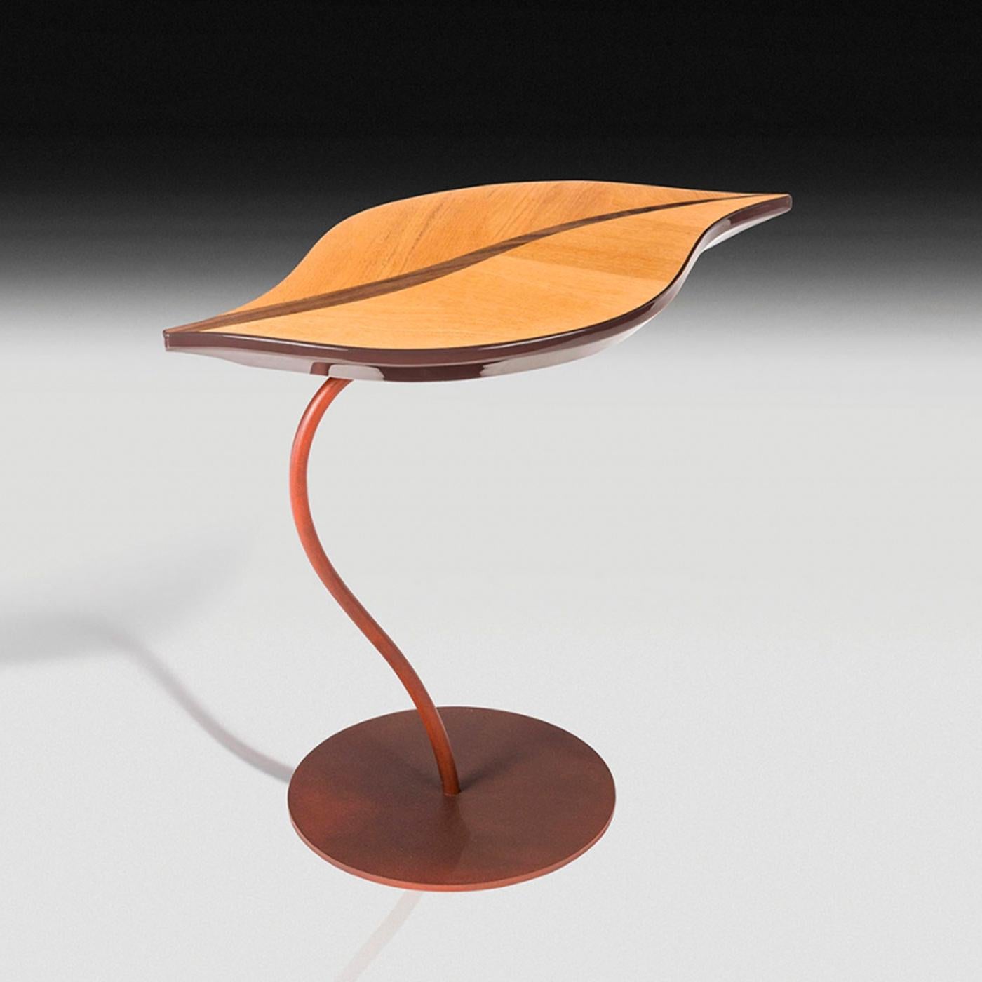 This stunning side table is an eye-catching addition to a modern interior, where it will add a dynamic and delicate accent to a living room or study thanks to its sinuous silhouette. The round base and curved stem are in steel with a Corten-like