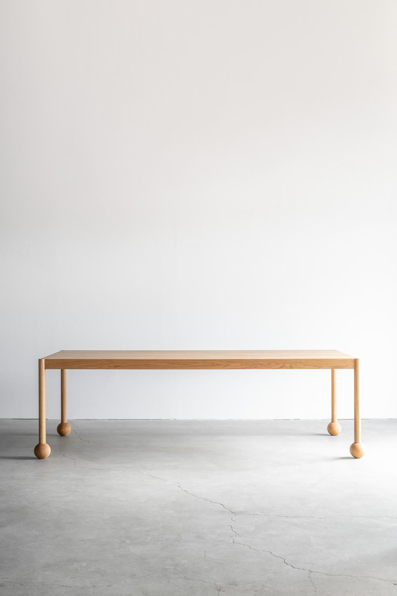 Associant l'élégance architecturale à des détails ludiques, la table à manger Fenn met en valeur la beauté naturelle du chêne à travers un objectif minimaliste. Fabriquée en chêne, la table présente un grain de bois naturel qui lui confère chaleur