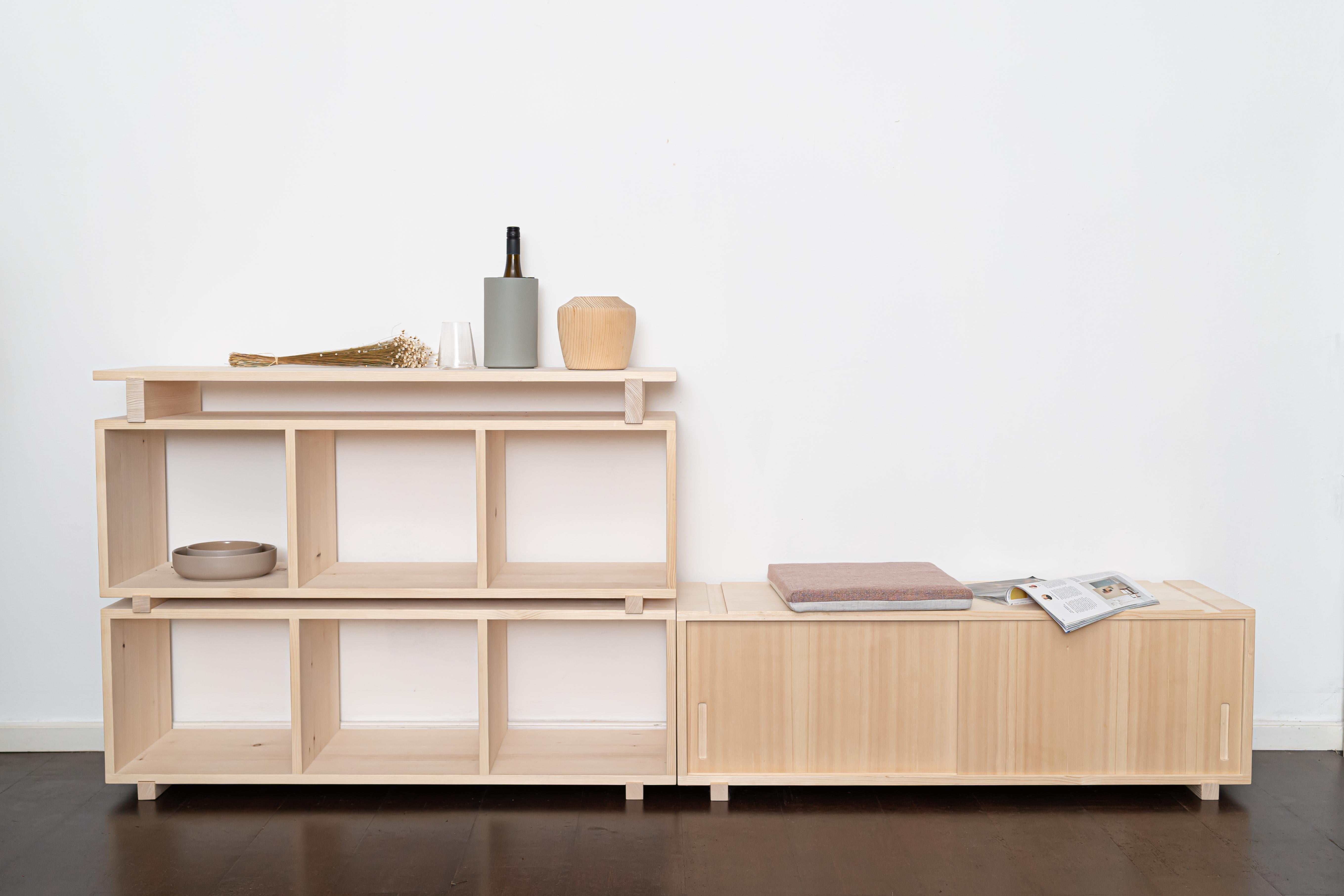 Modulares Feno-Regal von Frau Caze
Abmessungen: T 37 x B 120 x H 37 cm (Modul mit Schiebetür),
T 37 x B 120 x H 37 cm (Modul 3 Fächer),
T 55 x B 120 x H 2 cm (Regal).
MATERIALIEN: Natürliches Fichtenholz.

1 x Modul für die Schiebetür.
2 x Modul 3