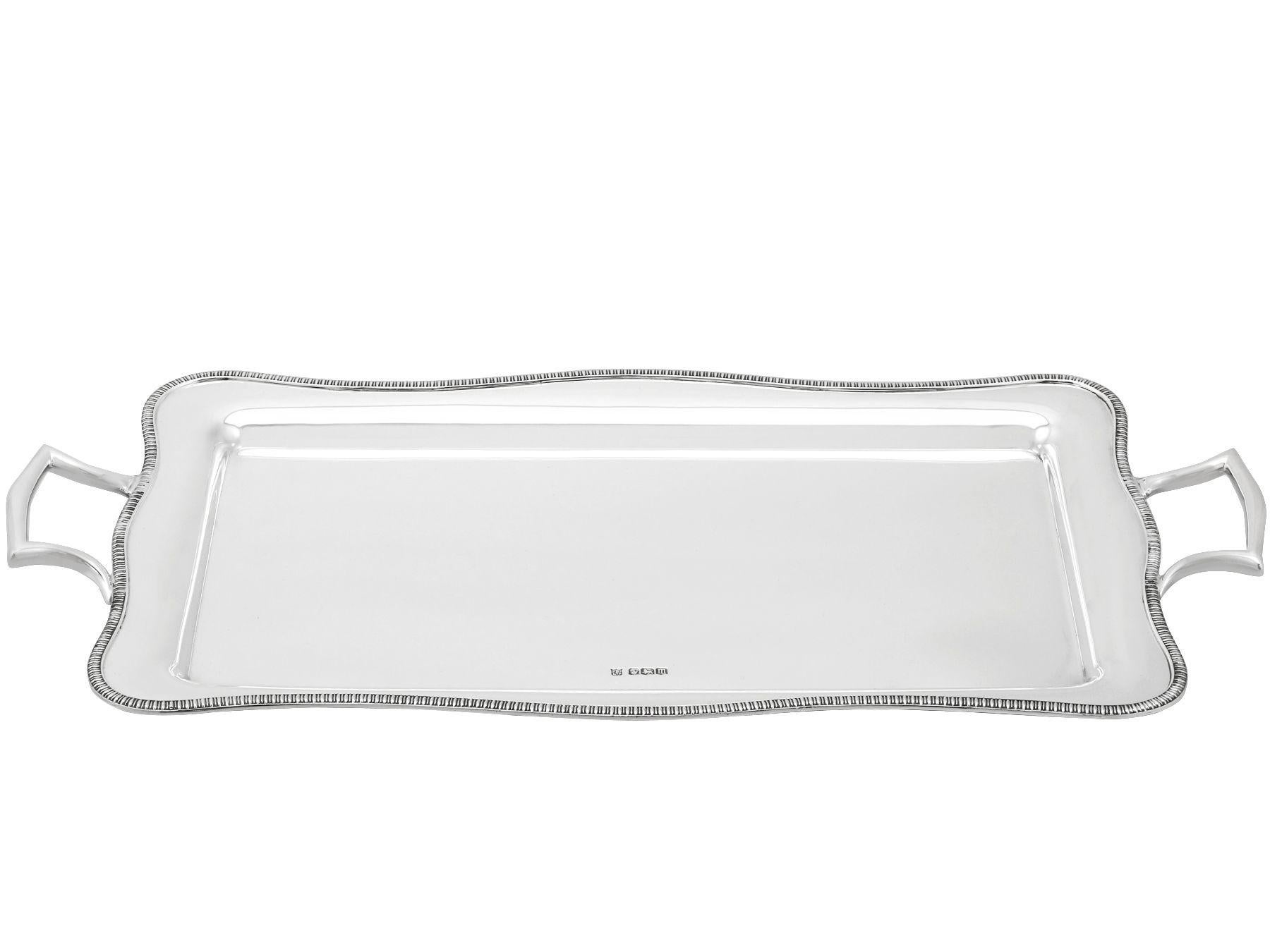 An exceptional, fine and impressive antique George V English sterling silver two handled drinks tray; an addition to our silver tray collection.

This exceptional antique George V sterling silver tray has a rounded rectangular form.

The surface of