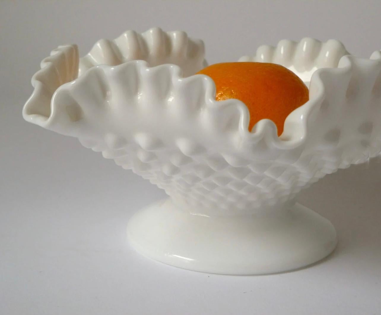 Handsome milk glass bowl stands on a short pedestal foot and is decorated with a hobnail pattern on the bowl. Great ruffled edge. Unmarked, but most likely made by Fenton, circa 1960.

Excellent vintage condition with no chips, cracks or