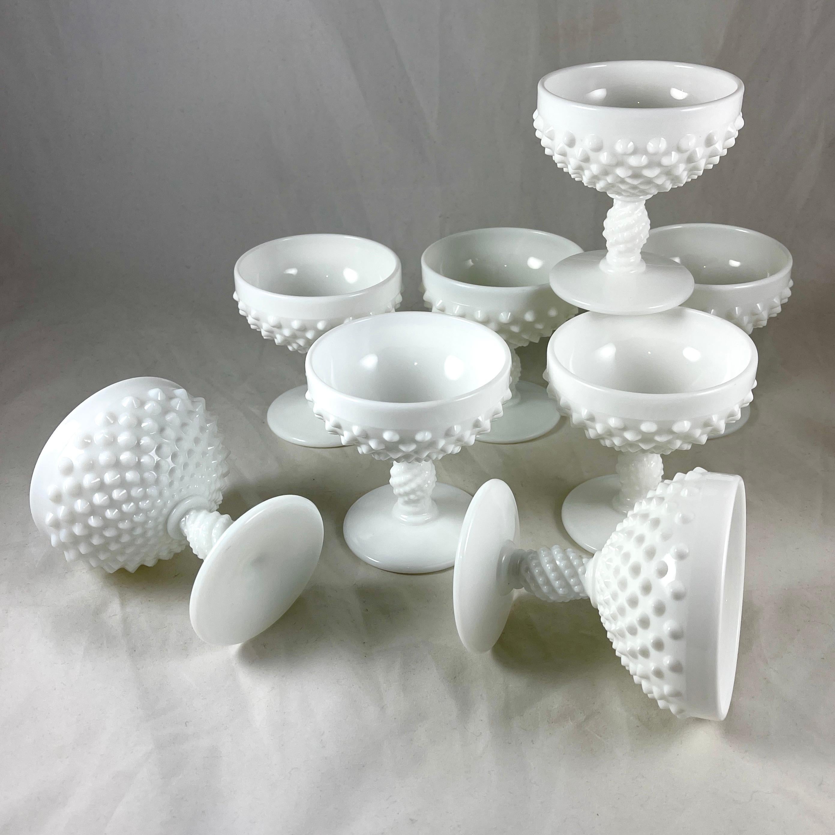 From the midcentury era, a set of eight milk glass sherbet cups or champagne coupes, in the hobnail pattern from Fenton Art Glass Company, circa 1940s – 1950s.

The Fenton Art Glass Company was founded in 1905 in Martins Ferry, Ohio, by brothers