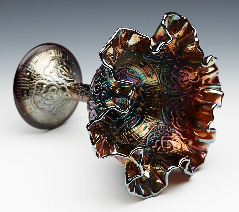 Ti offriamo questa eccezionale e straordinaria ciotola con piedistallo in vetro carnevalesco Fenton d'epoca, decorata con il disegno del medaglione persiano in una meravigliosa iridescenza viola o ametista e risalente alla prima metà del XX secolo.