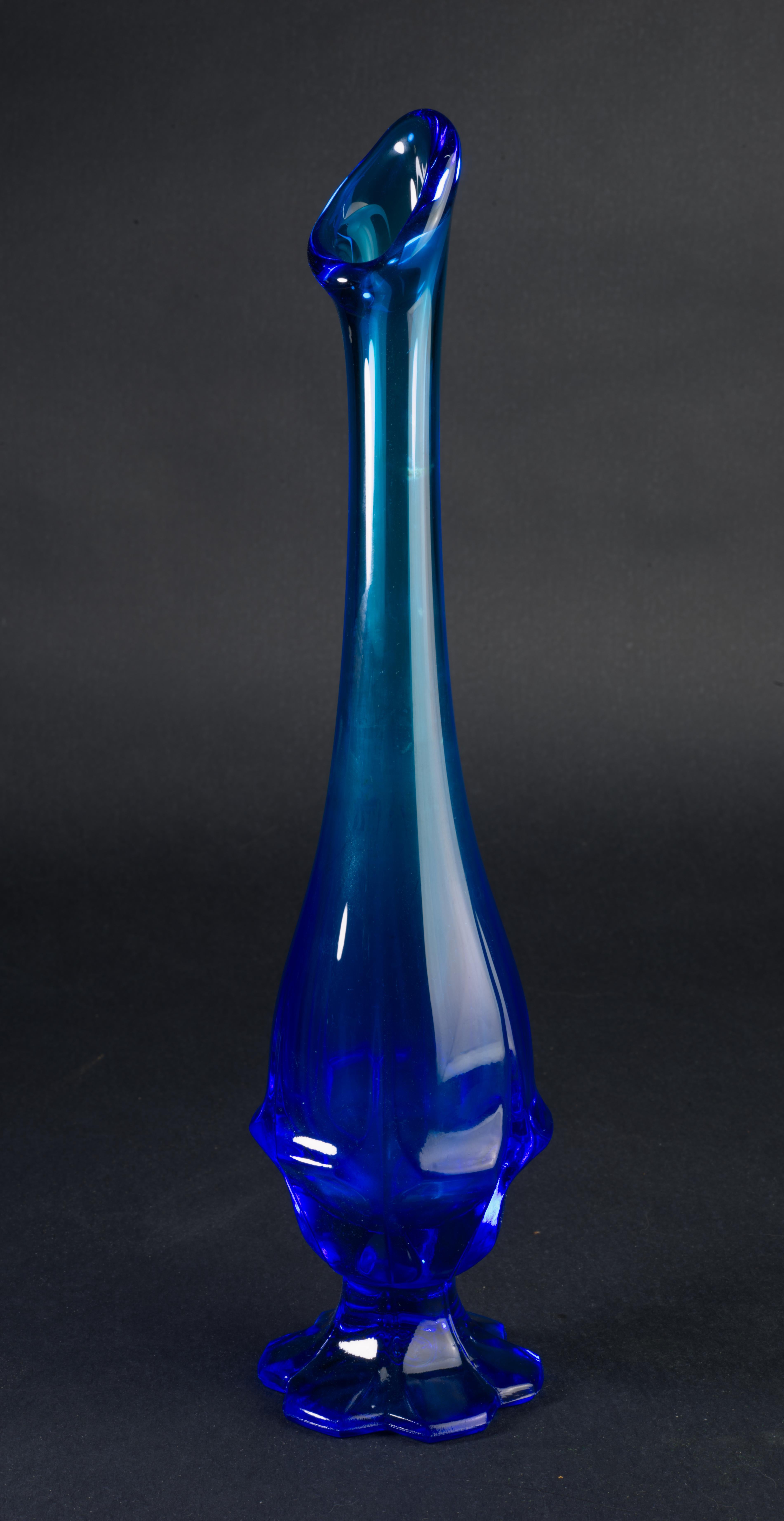  Rare swung bud vase in Colonial Blue color was made by Fenton as a part of Valencia Blue range. It was manufactured from 1969 to 1971, with the pattern described as elongated square pattern on a footed base. Bright blue color has an ombre