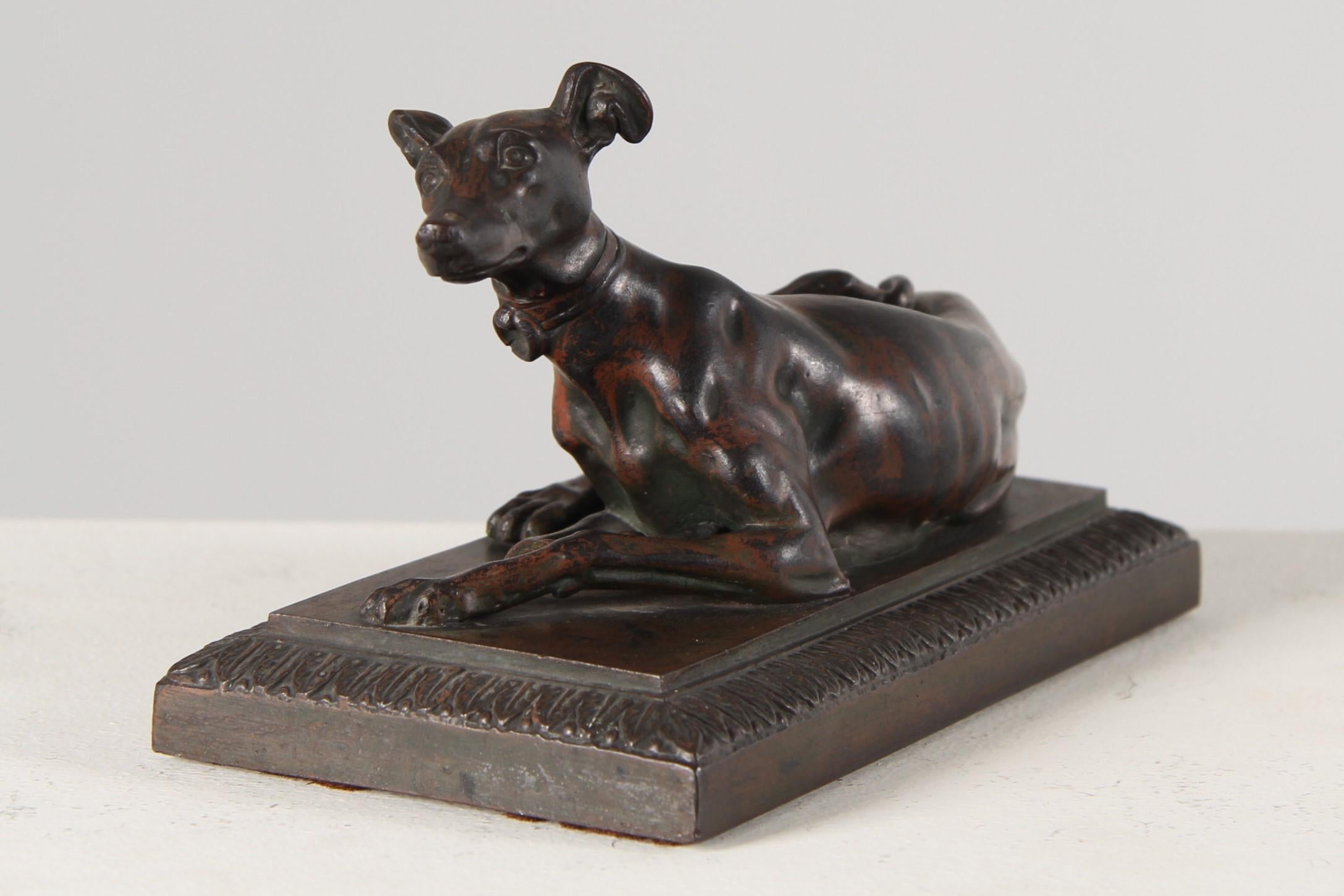 Fer de Berlin - Windhund als Briefbeschwerer

Berlin
Eisen
Biedermeier um 1830

Abmessungen: H x B x T: 9,5 x 17,1 x 8,8 cm

Beschreibung:
Auf einem Sockel liegender Windhund mit umlaufendem Palmblattfries. In der Ruheposition liegt das Tier in