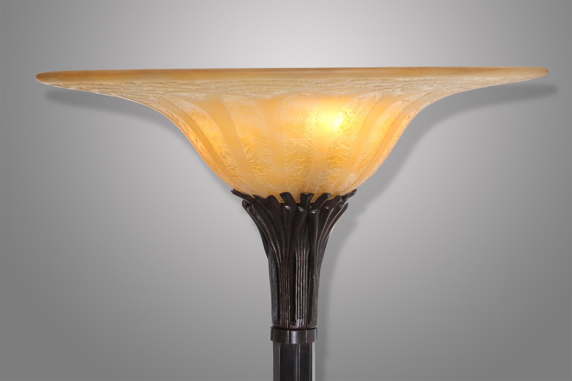 Really rare and exceptionnel torchiere by Raymond Subes from 1930. The piece is composed by an elegant hand-hammered wrought iron and a yellow Daum worked in rounded lines that can represent an almost floral decoration. 

The torchiere is also