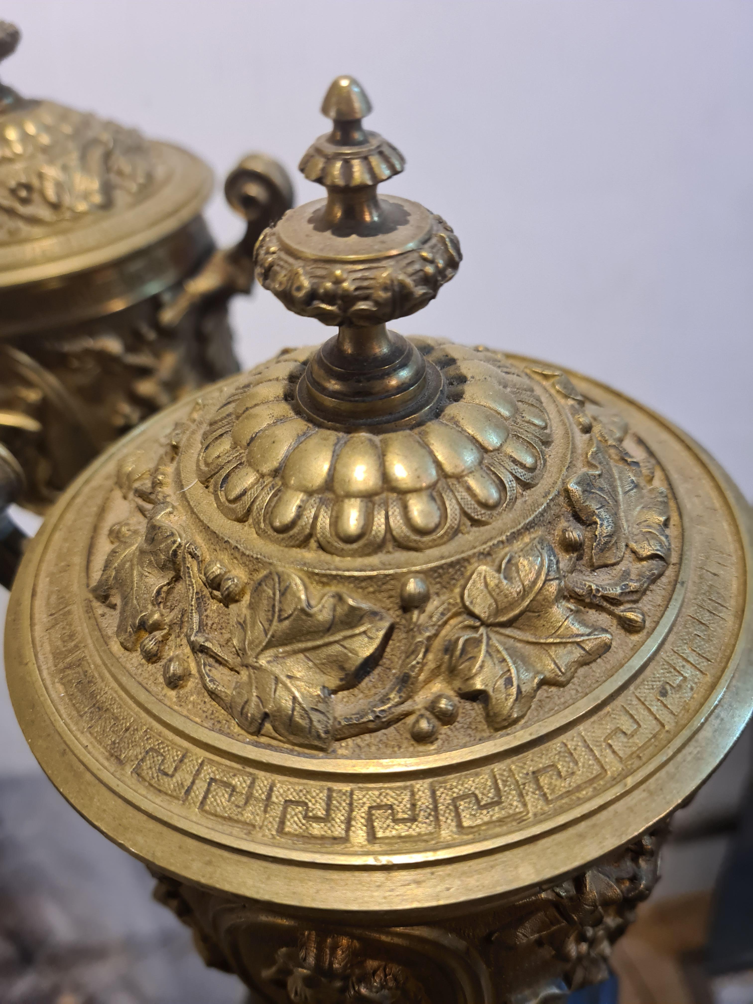A pair of French gilt bronze garniture urns on marble bases in the classical style. Though not signed the urns in style and quality are reminiscent of the work of Ferdinand Barbedienne.

The urns are beautifully decorated with stylised ivy with