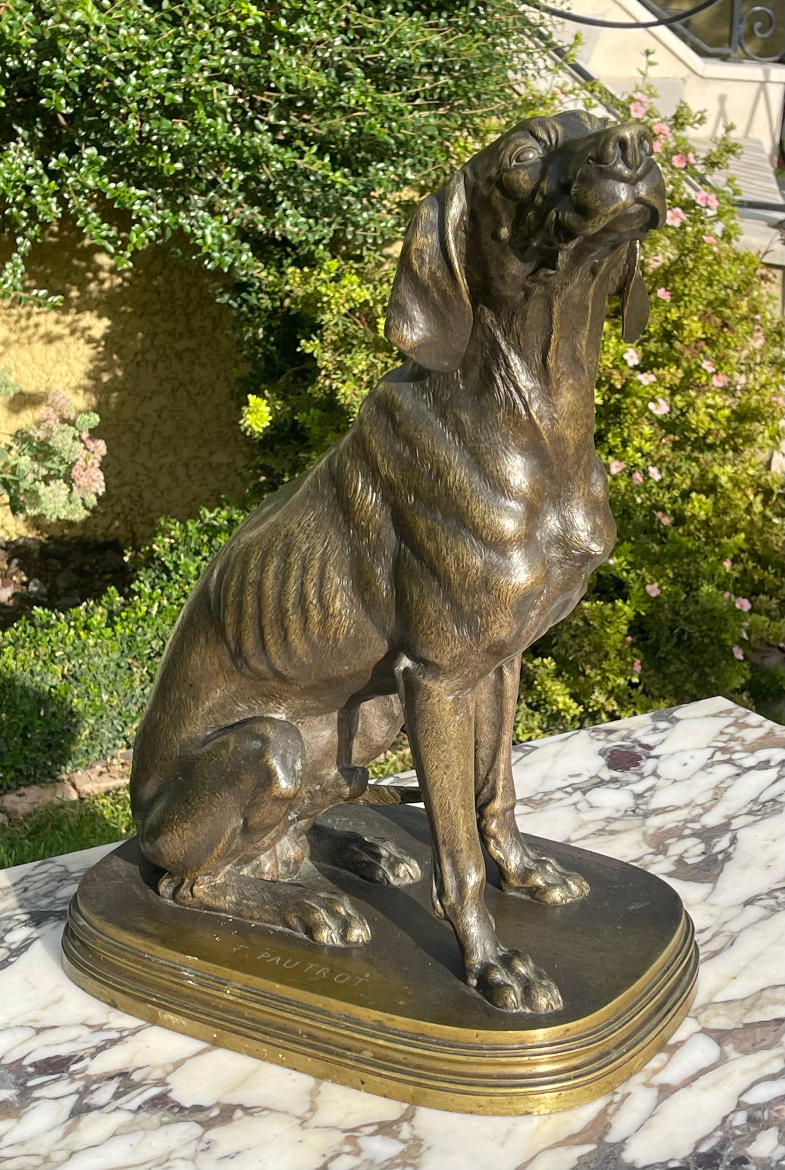 Bronze with a brown patina shaded with green representing a seated hunting dog signed on the base 