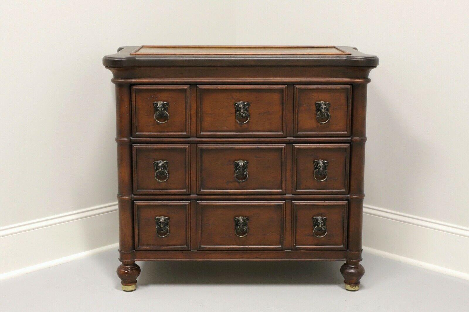 A Transitional style bedside chest by Ferguson Copeland, from their Highlands Collection. Hardwood construction with faux bamboo columns and trim. Three dovetail drawers with brass lion head pulls. Inlaid painted metal top with tooled leather