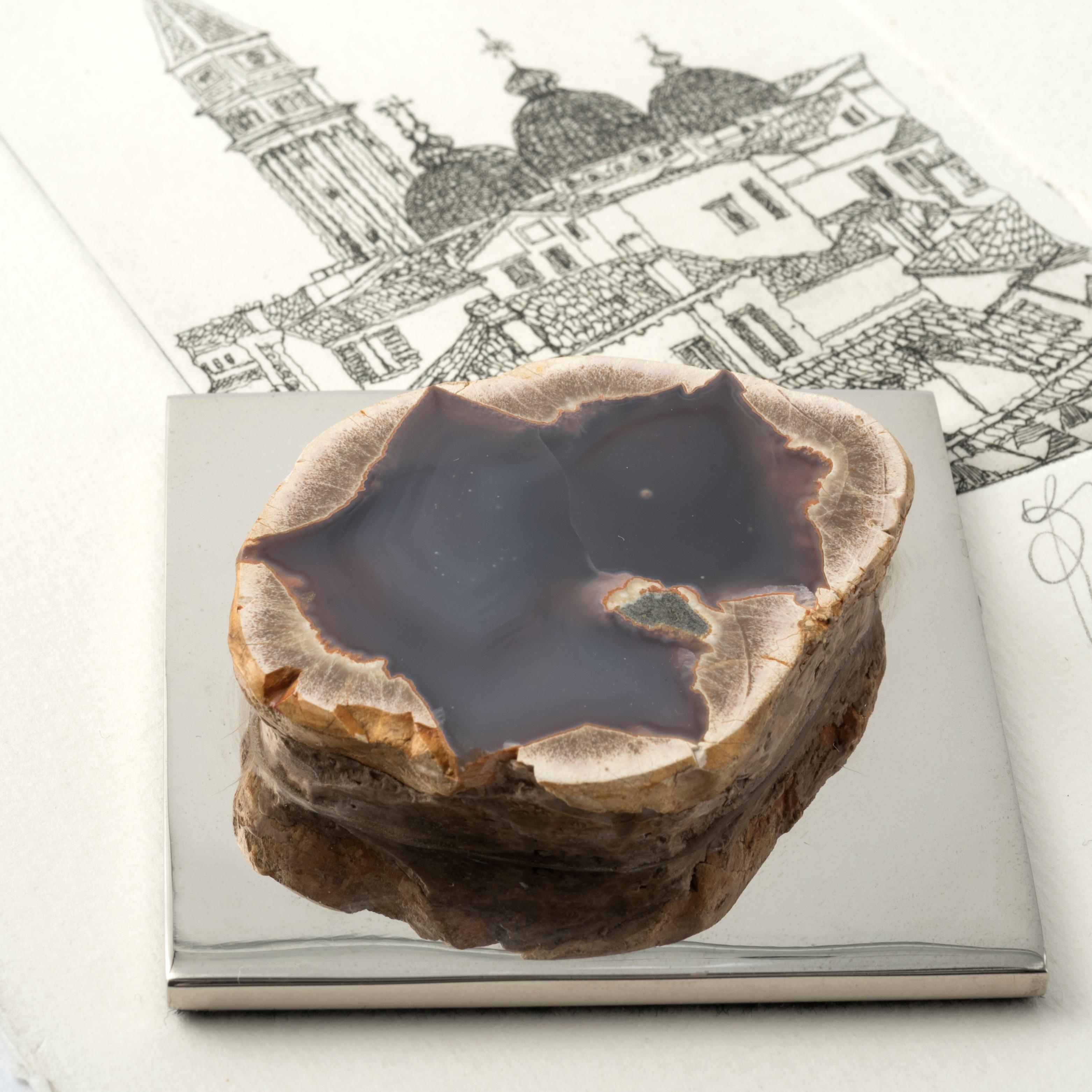 Dieser elegante Briefbeschwerer ist Teil der Fossiline-Kollektion, einer Reihe von Dekorationsobjekten, die die Schönheit von Natursteinen unterstreichen.
Der quadratische Sockel aus poliertem, vernickeltem Messing beherbergt eine Geode aus