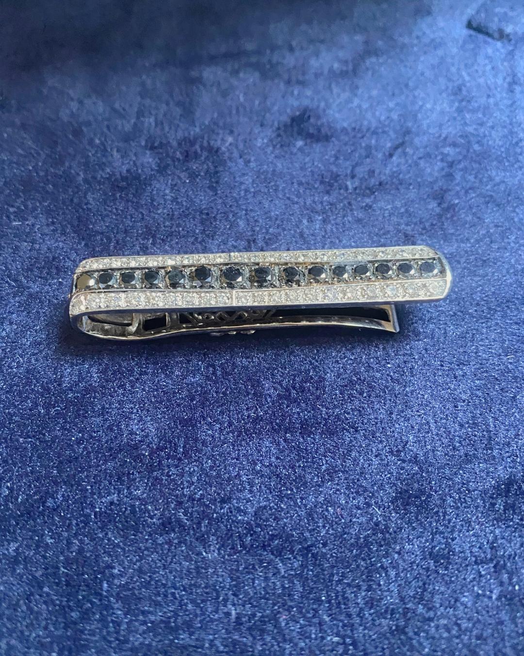 Une pince à billets en or blanc 750‰ au design él�égant et contemporain, réalisée avec un grand savoir-faire pour allier fonctionnalité et raffinement en un seul objet de valeur. La surface méticuleusement détaillée est ornée d'un jeu raffiné de