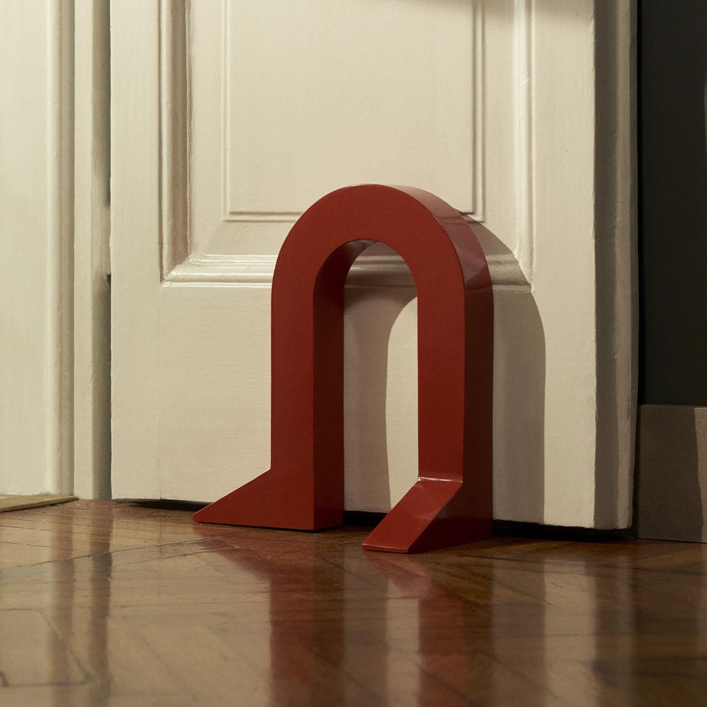 Fermo is a metal doorstop, characterized by a playful anthropomorphic form, expertly shaped from a thick slab, giving the project robustness and durability. The two legs, positioned with a touch of irony, not only convey a sense of stability to the