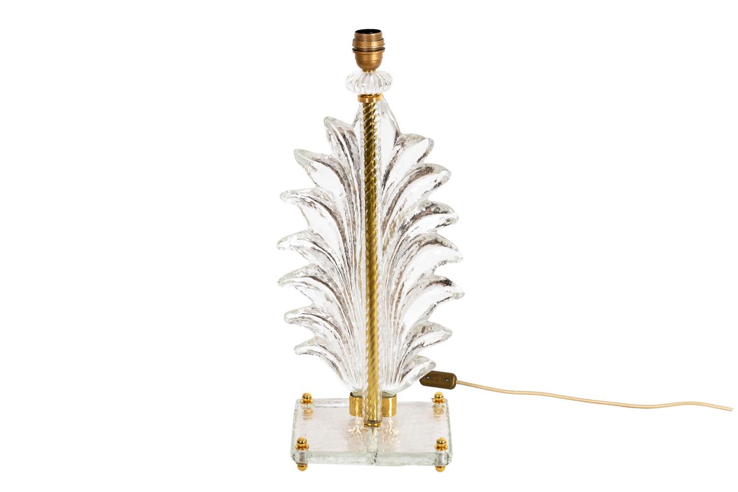 Fern lamp in Murano glass with a fern shape shaft hung to a swirl shaft by a gilt brass link, topped by a flat gadroons ball and finished by a gilt brass ring. Rectangular glass base standing on four small gilt brass shoes.

Italian work realized