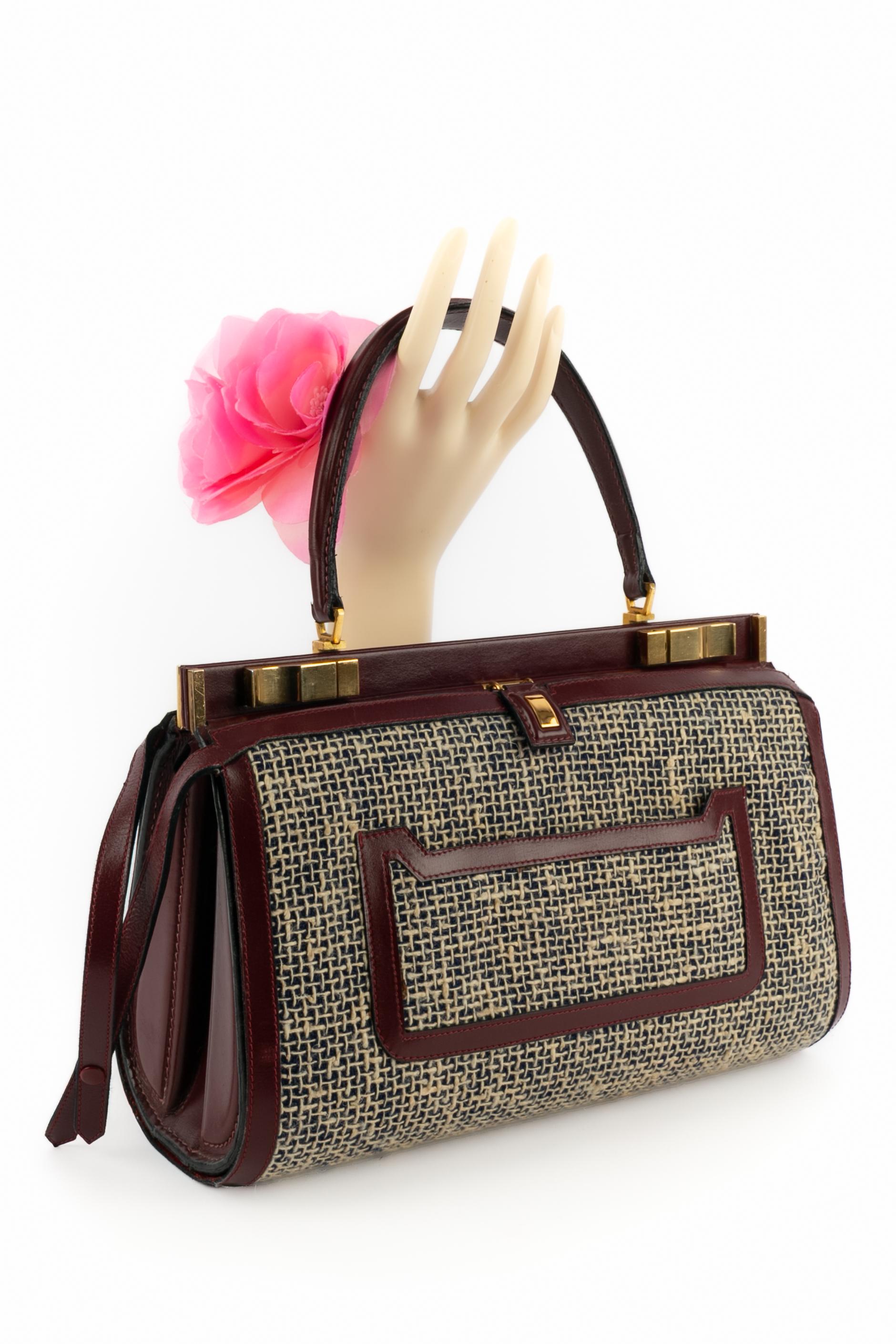 FERNANDES DESGRANGES - (Fabriqué en France) Sac rigide en cuir bourgogne avec tissu façon tweed. Sac des années 1960.

Condit :
Très bon état.

Dimensions :
Hauteur : 21 cm - Largeur : 29 cm - Profondeur : 13 cm - Poignée : 38 cm

SKU:S236