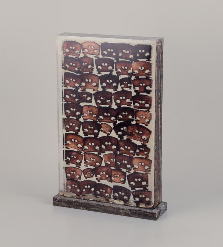Fernandez Arman (1928-2005), artiste américain d'origine française.
Accumulation de chevalets de violon en bois brûlé encastrés dans de la résine polyester, encadrés dans du plexiglas. 
Base en marbre norvégien Porsgrunn. 
Signé Arman, 18/100.